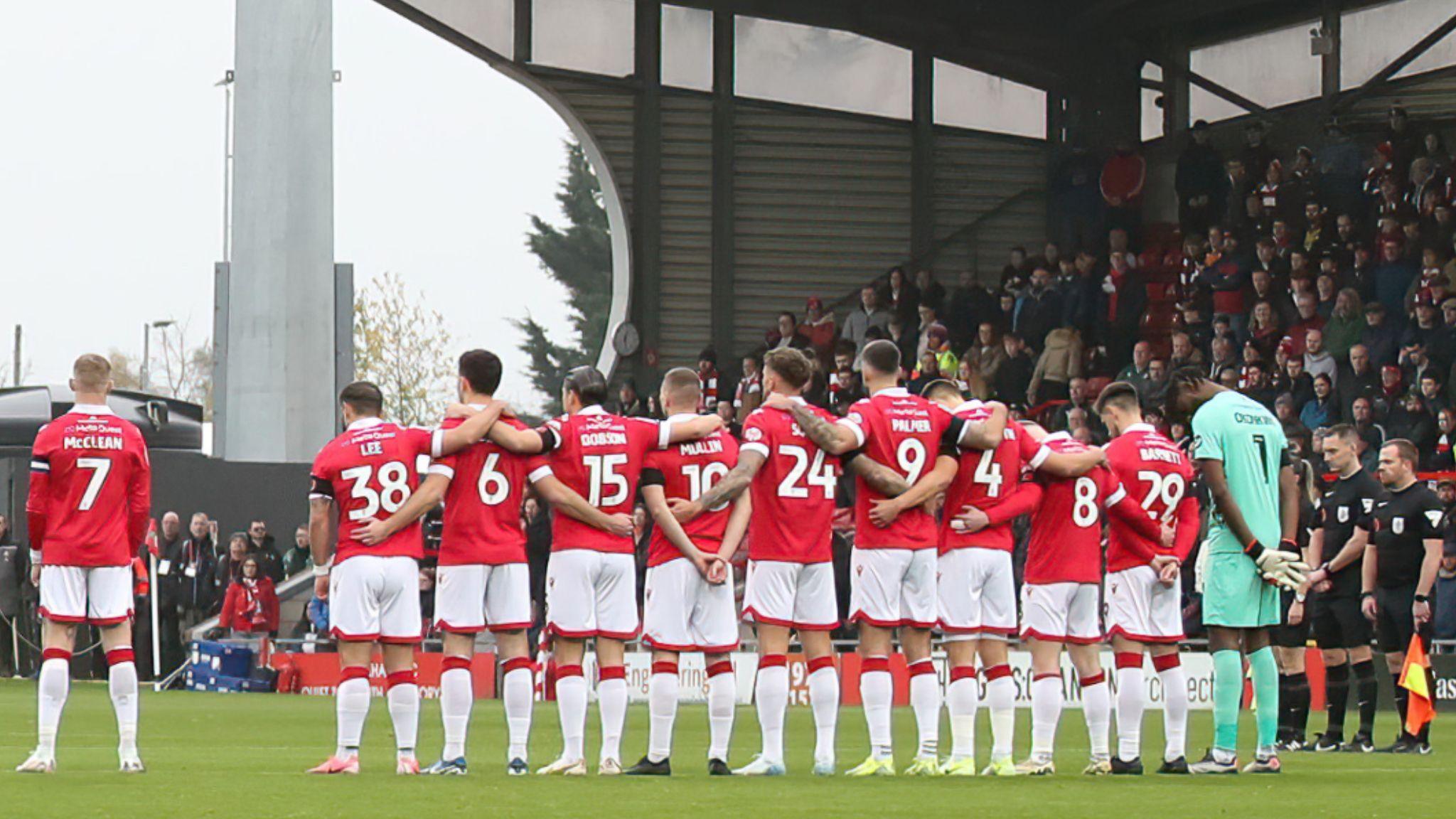 James McClean stands away from teammates during the minute’s silence for Remembrance Day held prior to Wrexham’s game with Mansfield.