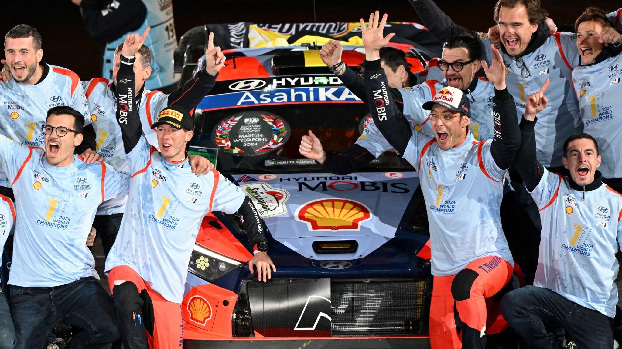 Thierry Neuville and his co-driver Martijn Wydaeghe of Belgium celebrate their World Champion with their team staffs on the podium at the Toyota stadium during the 2024 Rally Japan