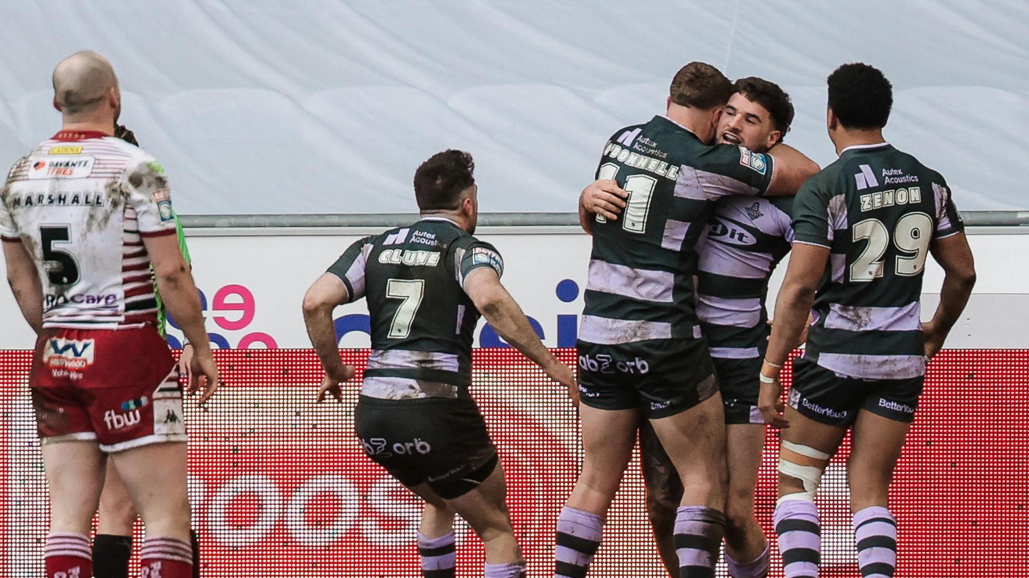 Connor Wrench (right) is mobbed by three team-mates after scoring a try as Liam Marshall (MARSHALL- 5) looks on 