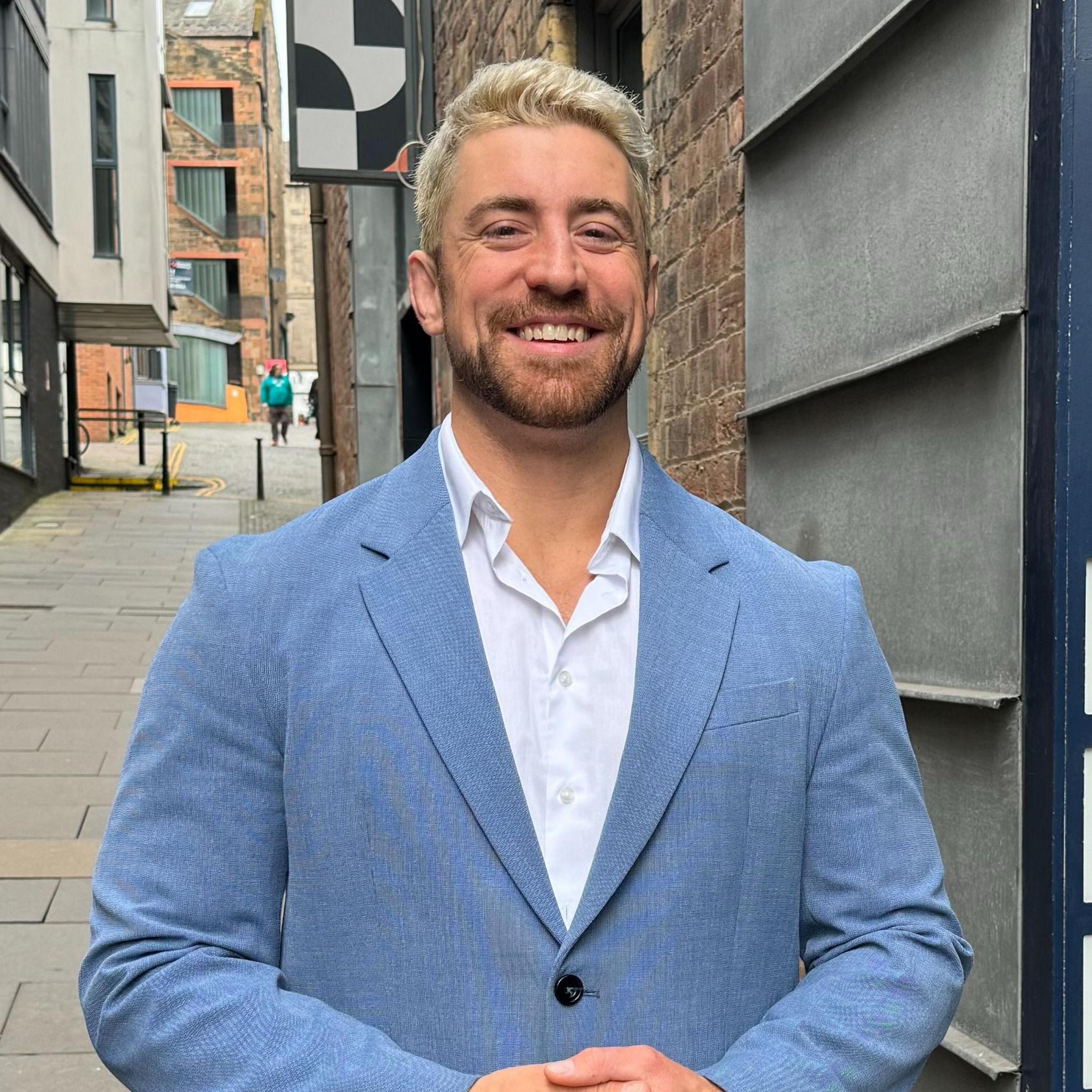 Wrestler Joe Hendry standing outside ý building in Edinburgh