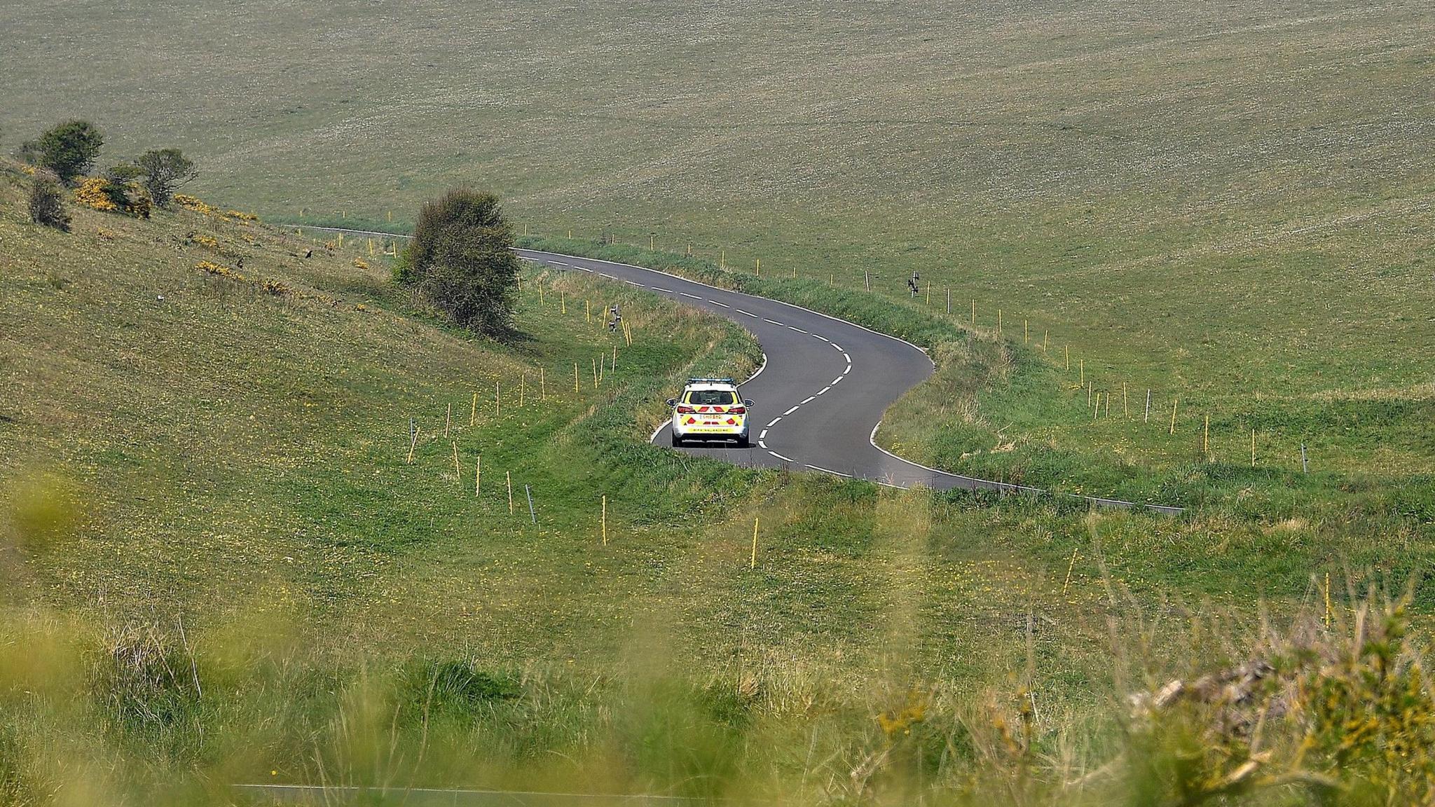 A police car driving near a bend in Beachy Head Road near Eastbourne