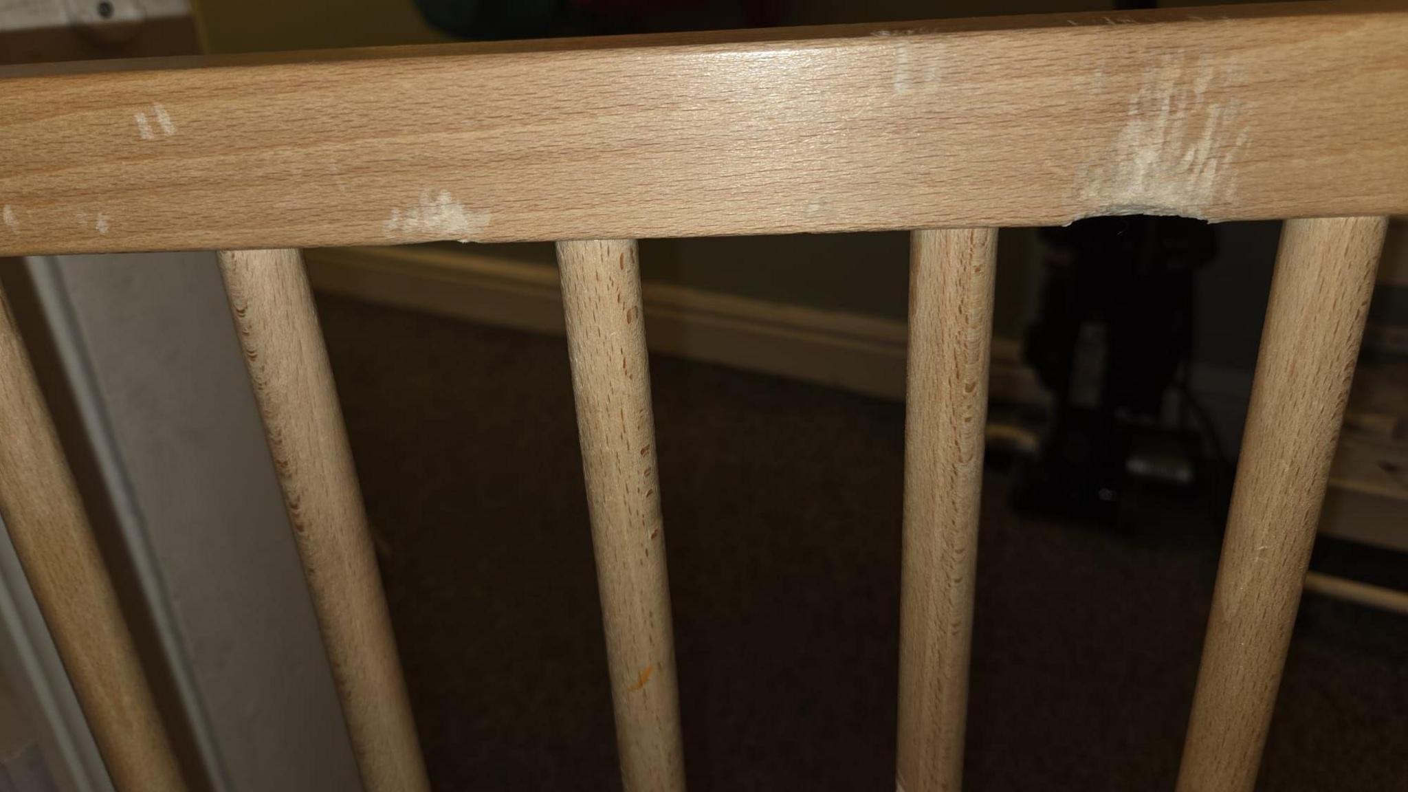 A wooden gate with bite marks in it.