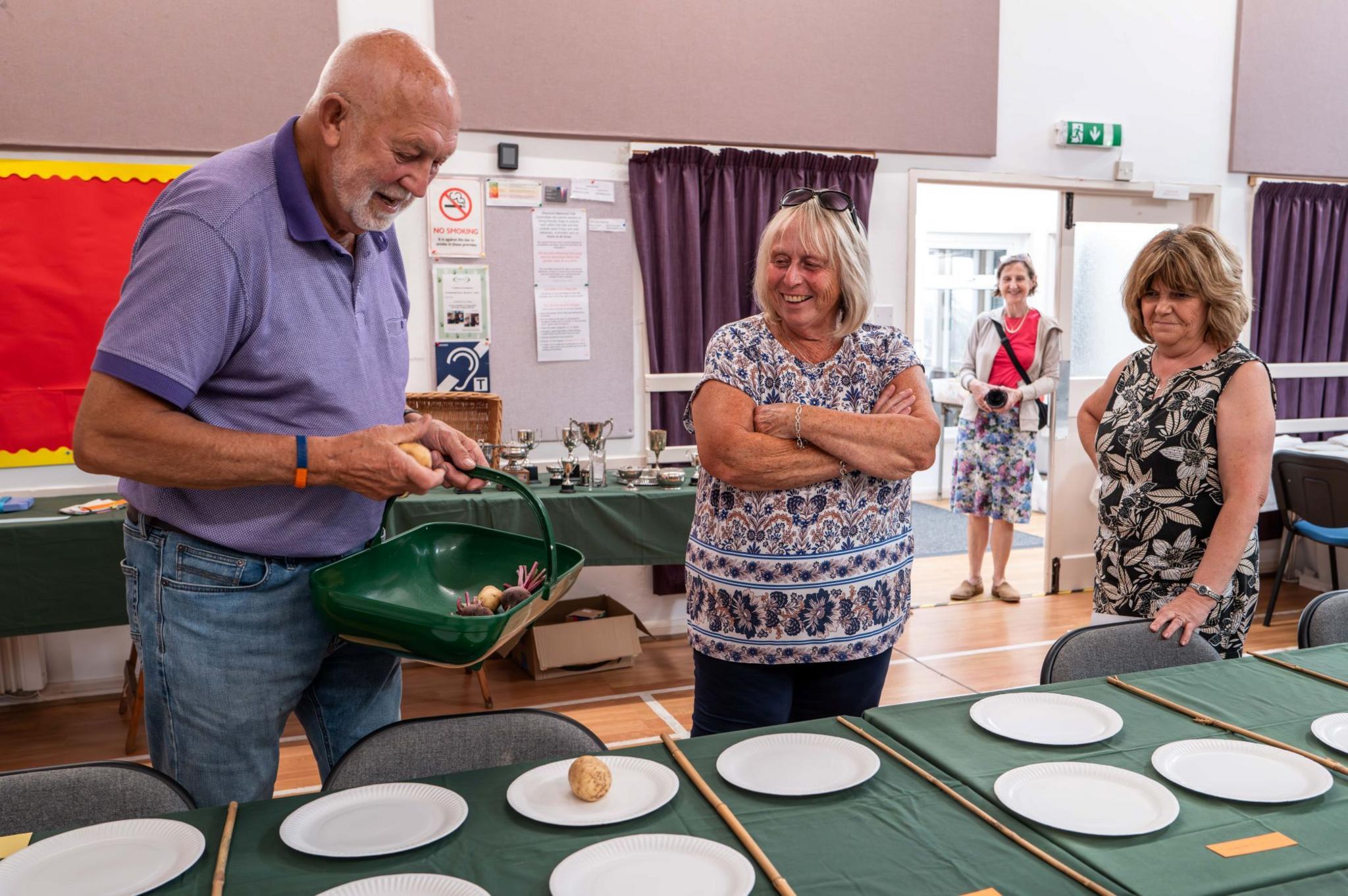 People place vegetables on plates ahead of the opening of the show