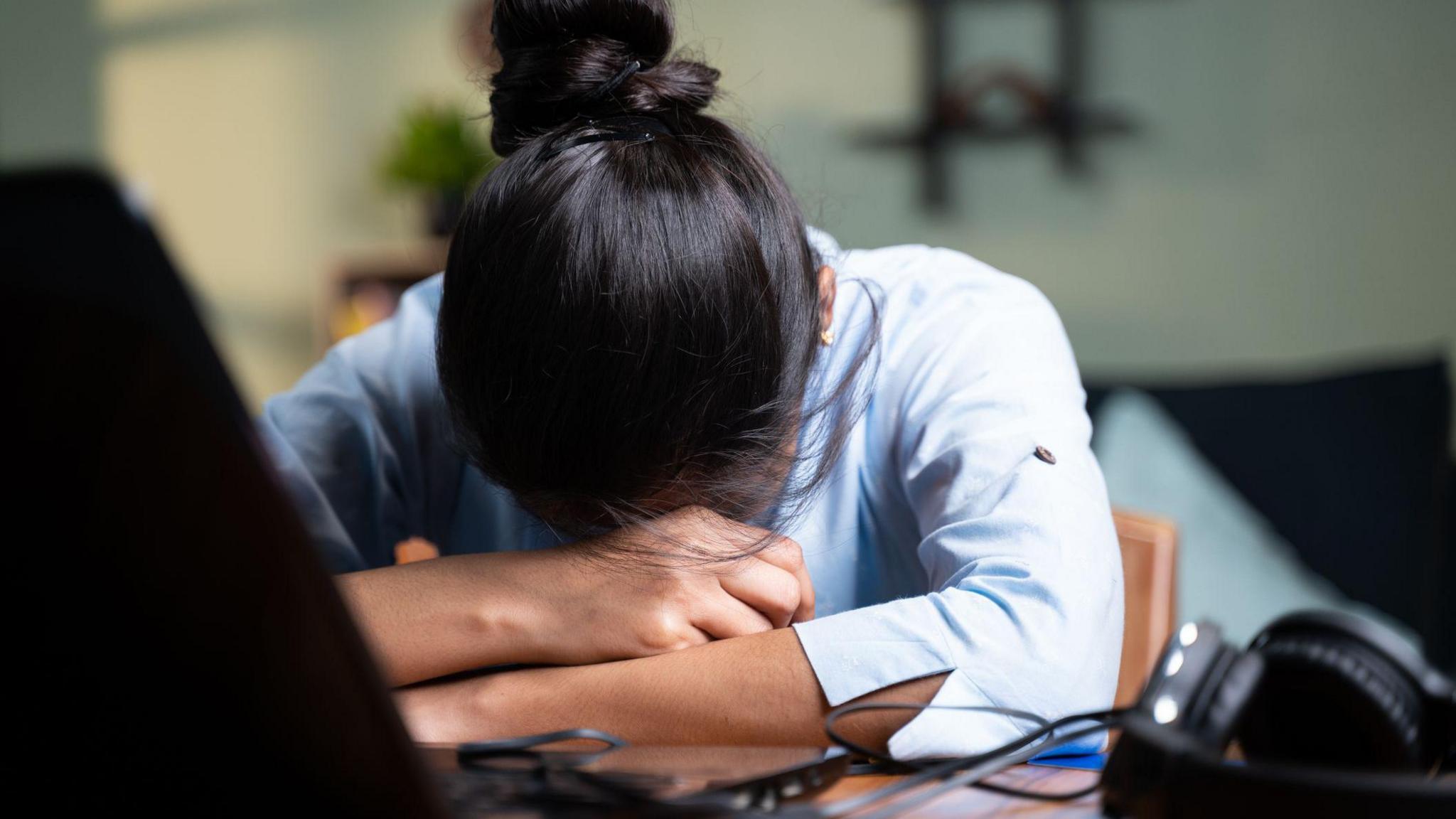 Young Business woman sleeping by closing laptop while working, concept of new normal burnout, over or late night work at home during coronavirus covid-19 pandemic - stock photo