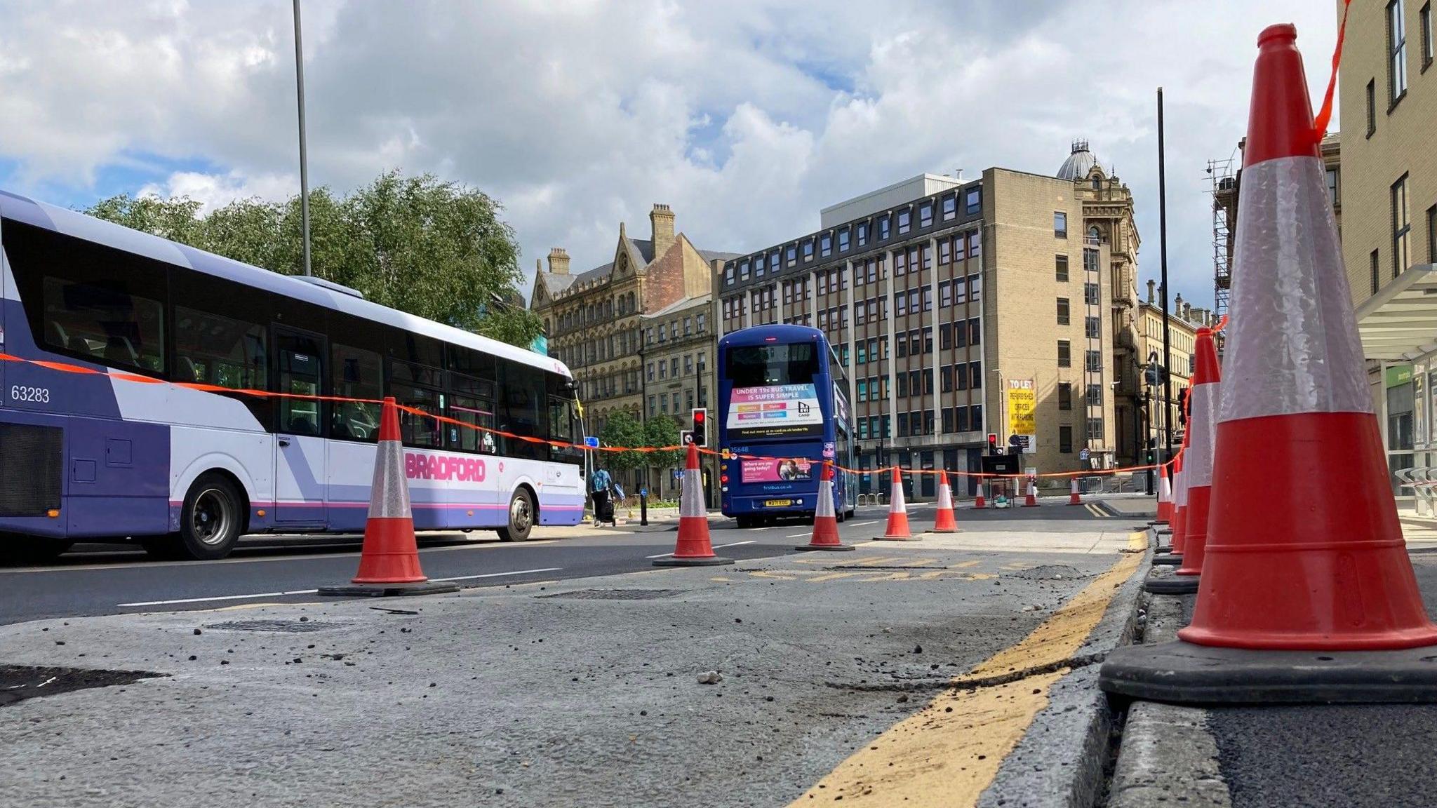 The newly-laid road surface buckling at the kerbside due to flooding