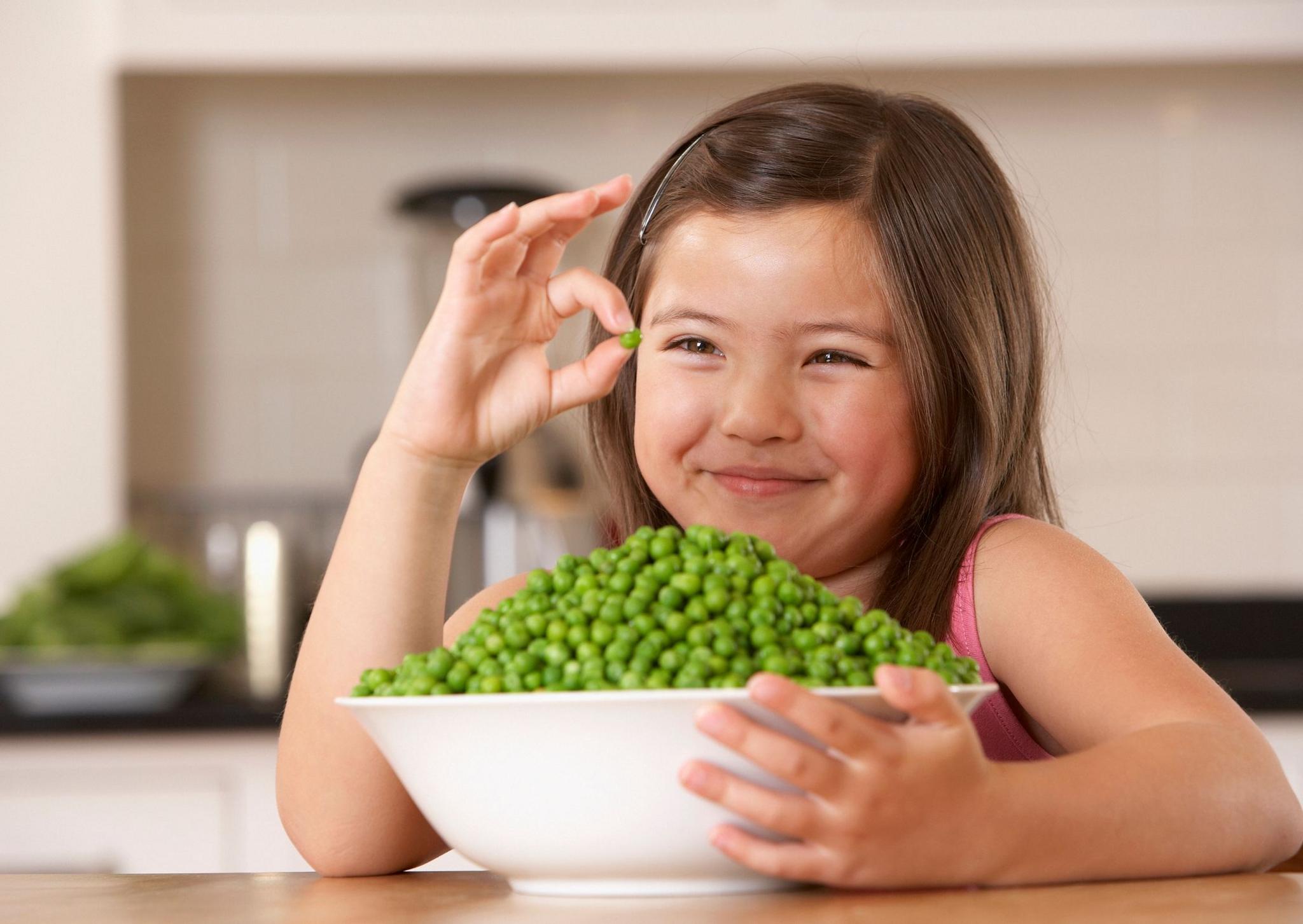 Girl with a bowl full of peas