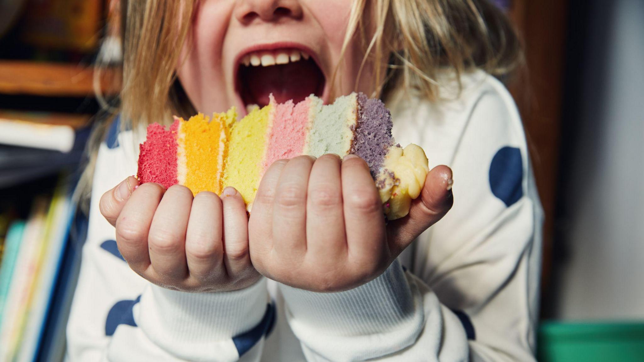 Child holding a piece of birthday cake.