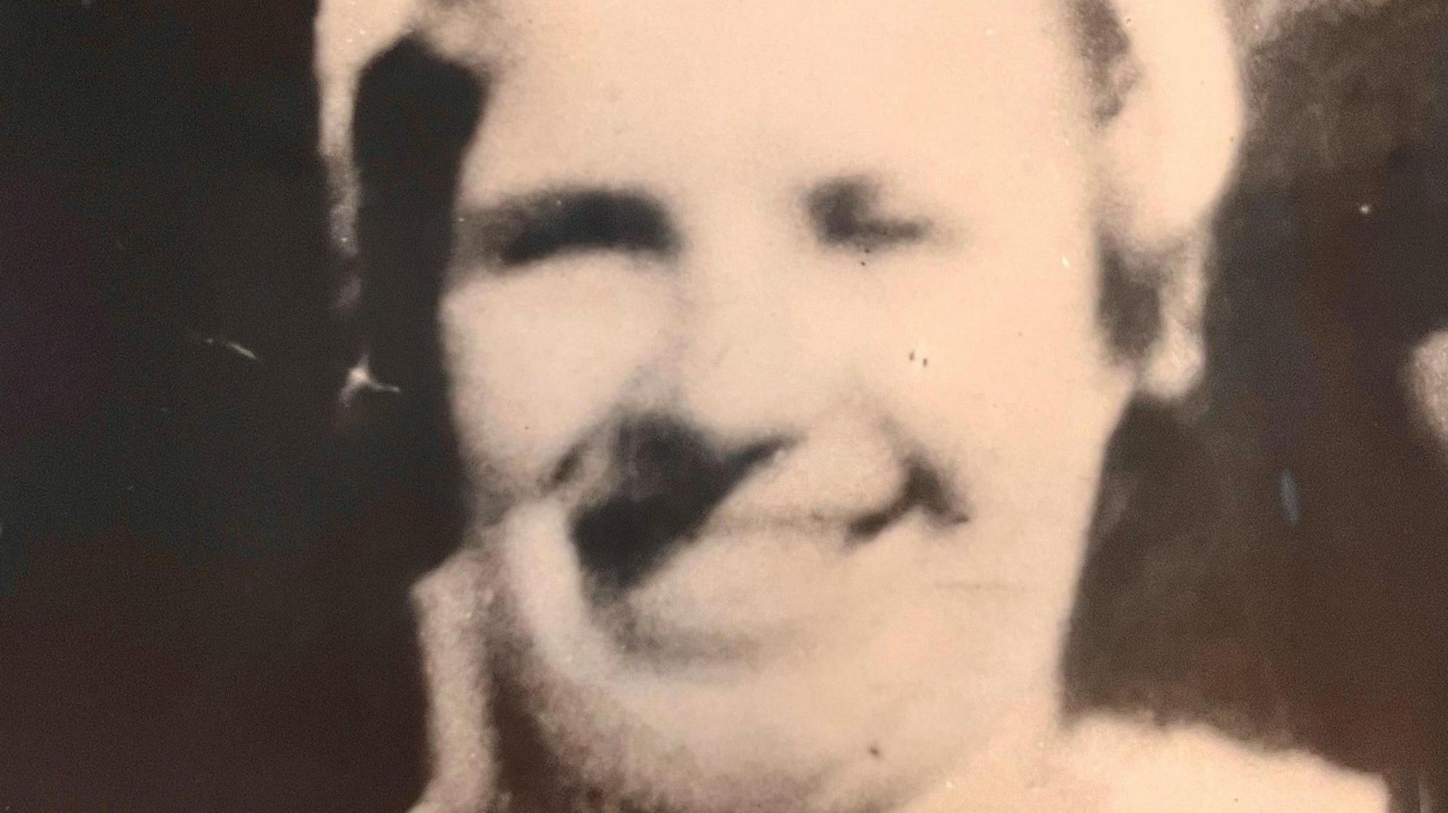 Blurred black-and-white picture of Mary Rogerson, who is smiling as she poses for the camera.