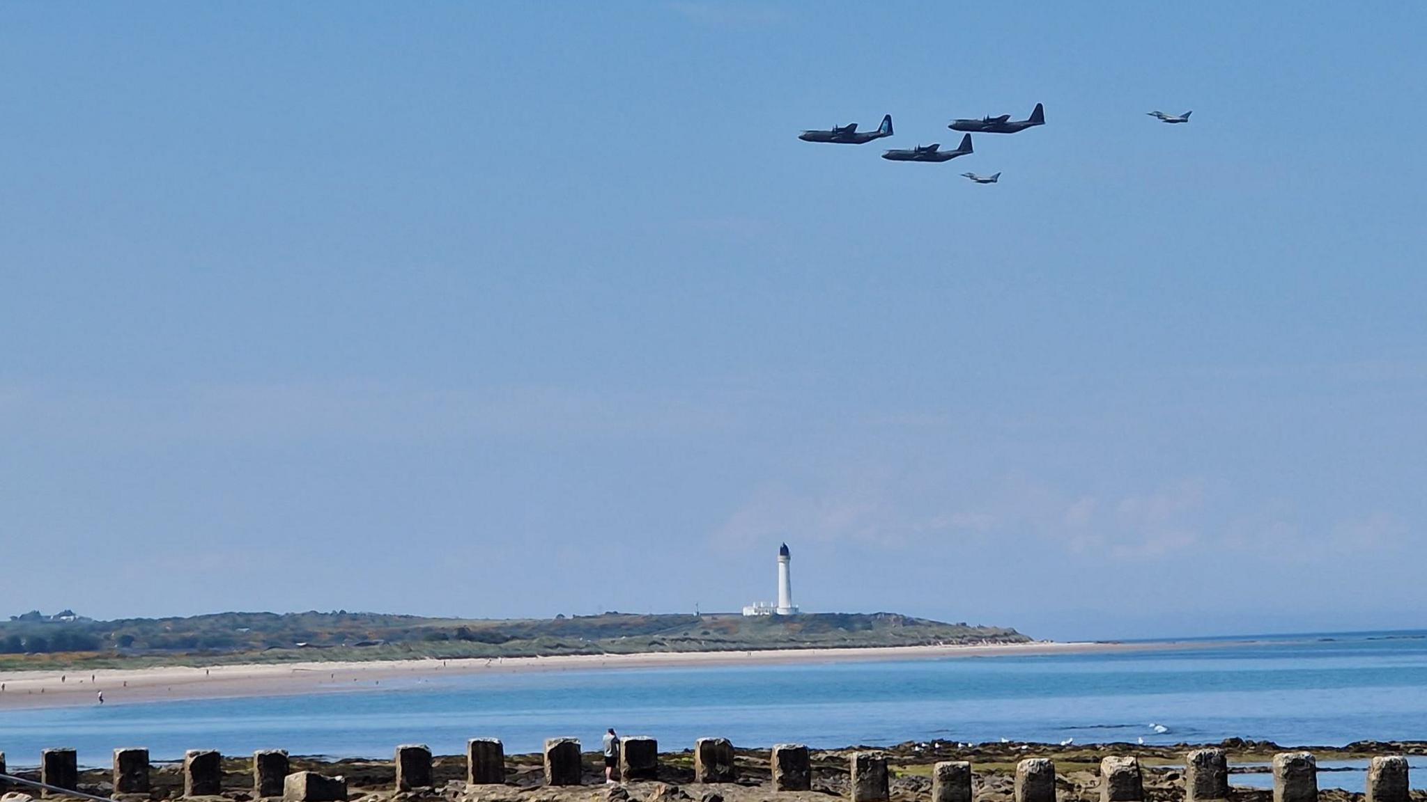 Two Typhoons and three Hercules overhead the lighthouse at Lossiemouth