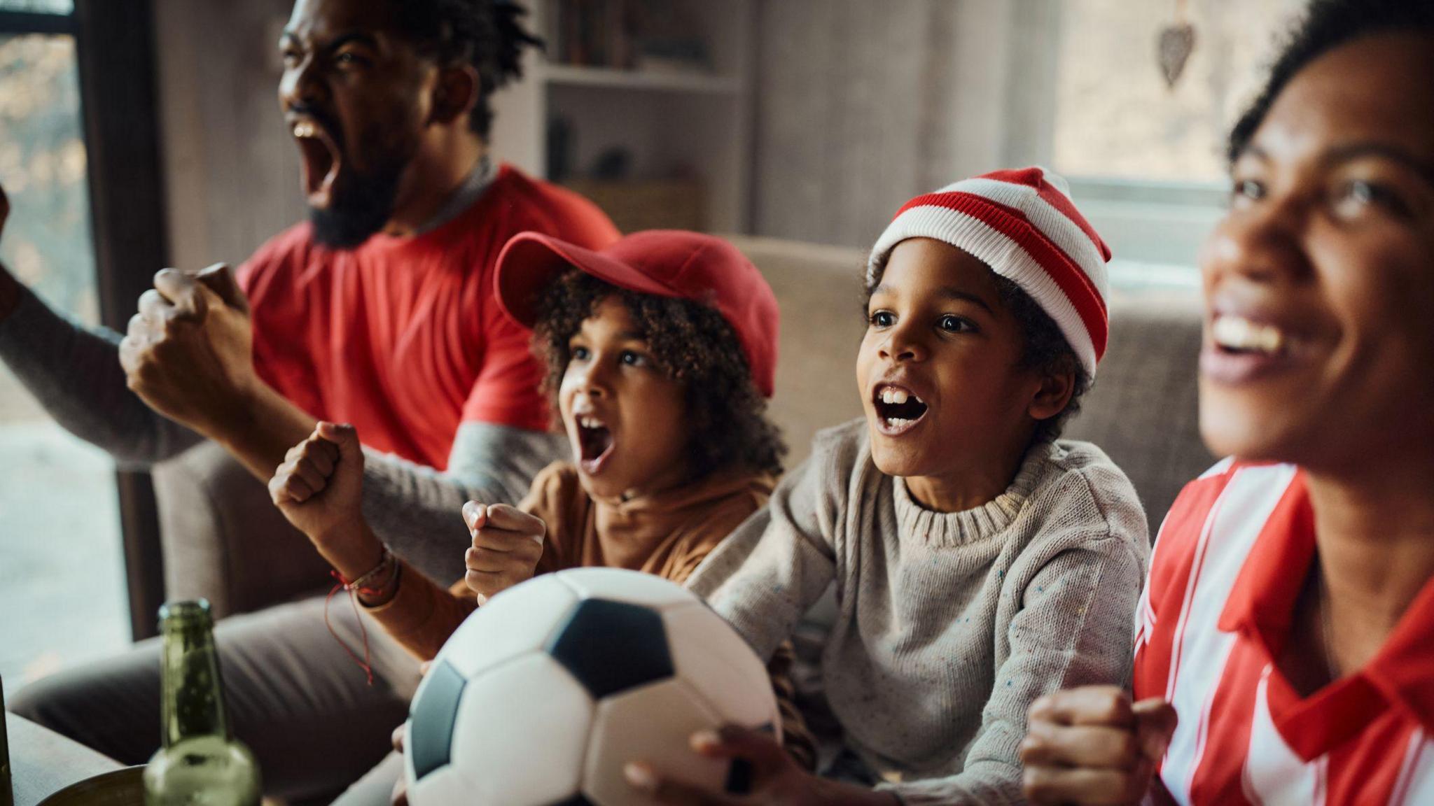 Family watching a football match together.