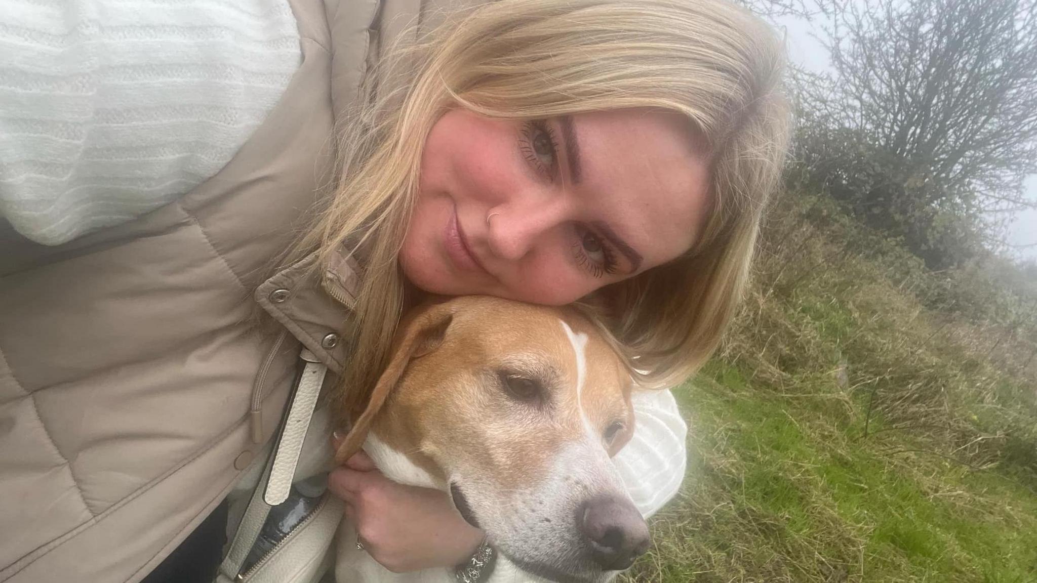 A woman and her dog in a selfie outside