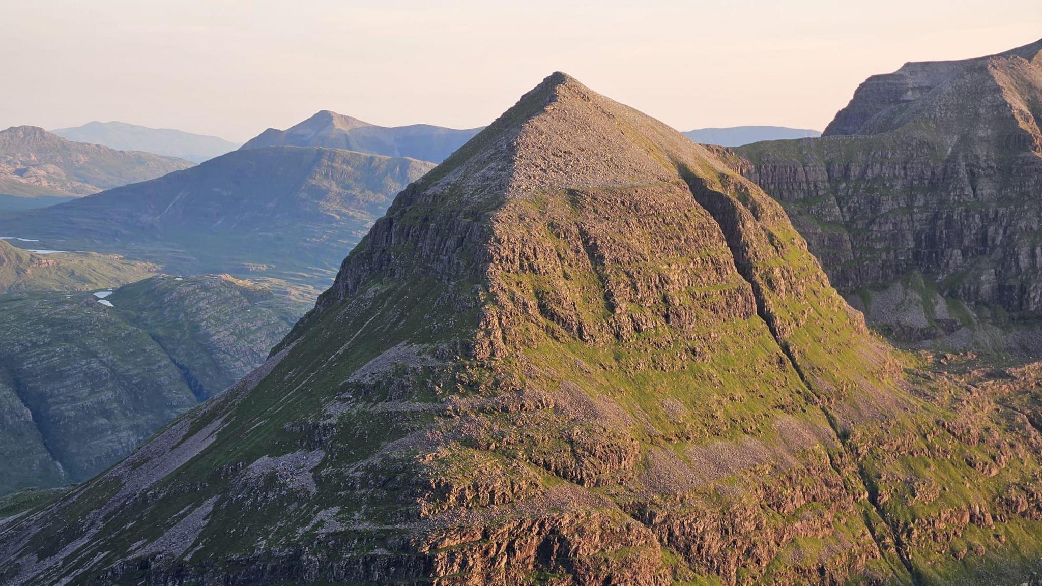 Beinn mhòr le beanntan eile air a cùlaibh