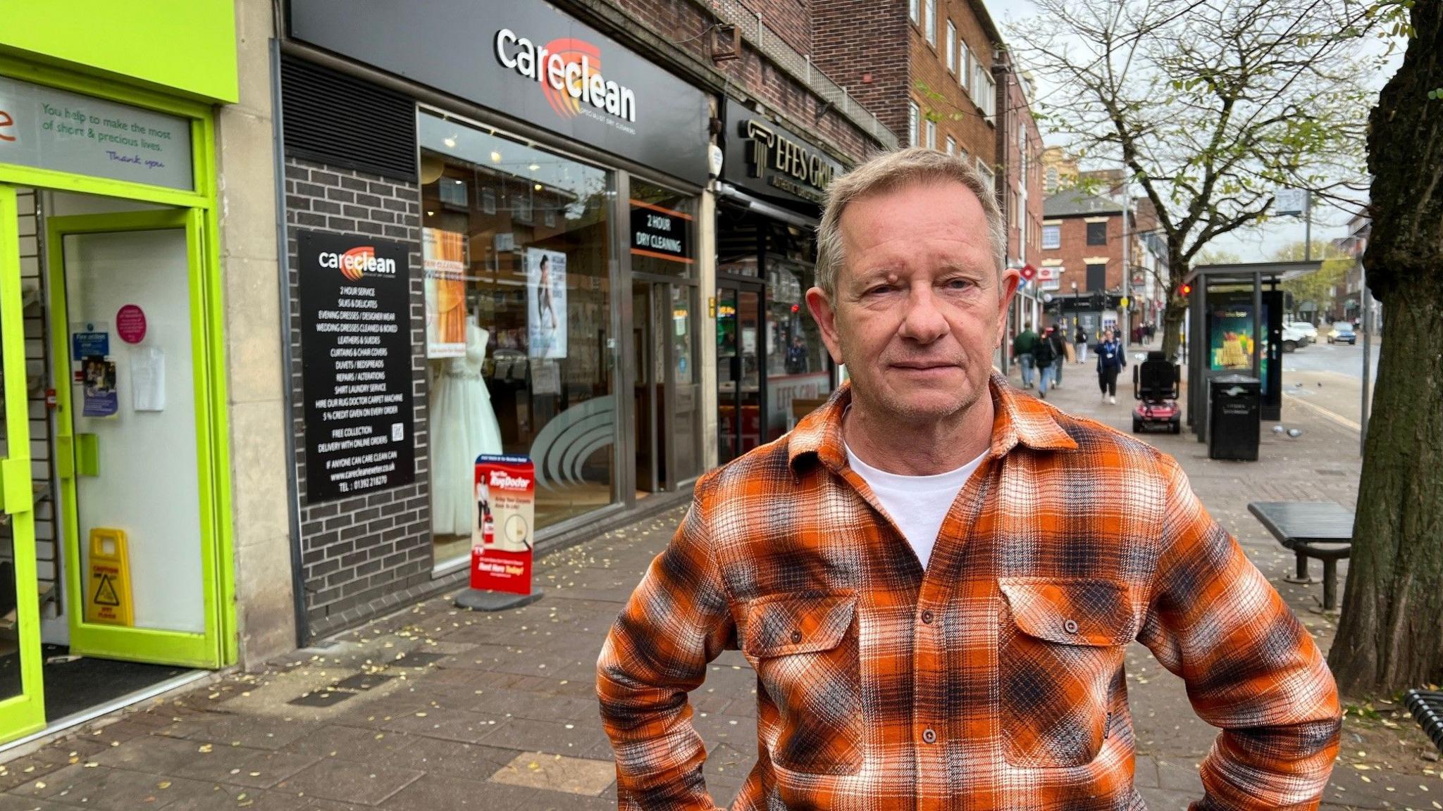 Nick Wedgery wearing an orange check shirt on Sidwell Street outside his CareClean business