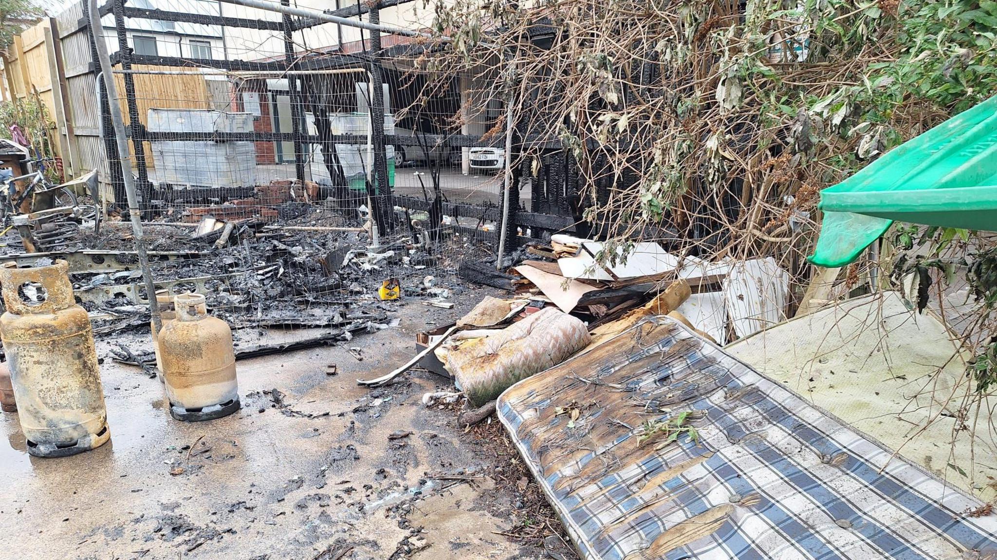 A mattress lying close to charred remains