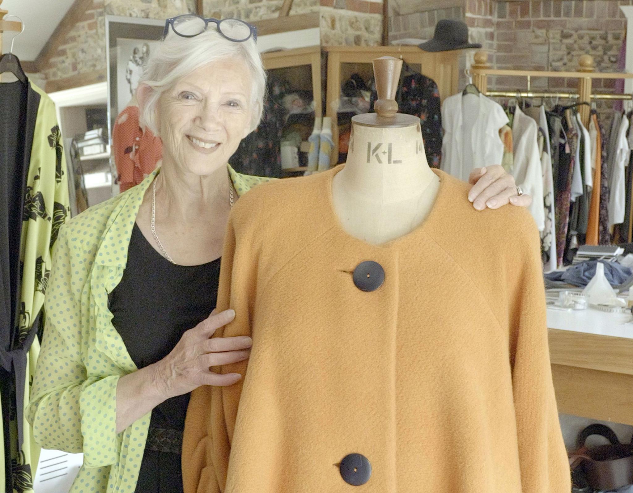 Jean Pallant posing with an item of clothing in a store