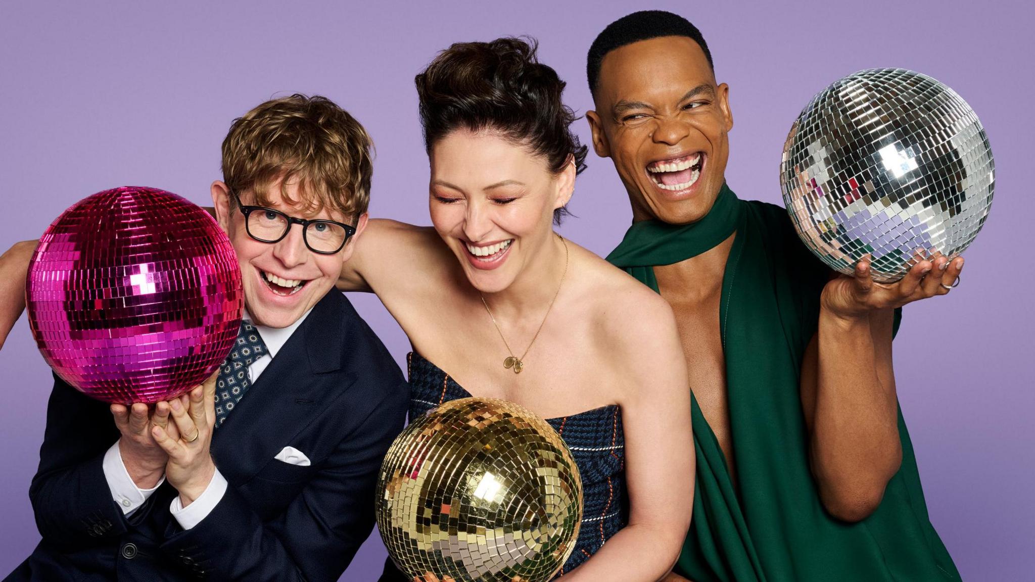 Johannes Radebe, Emma Willis and Josh Widdicombe holding disco balls