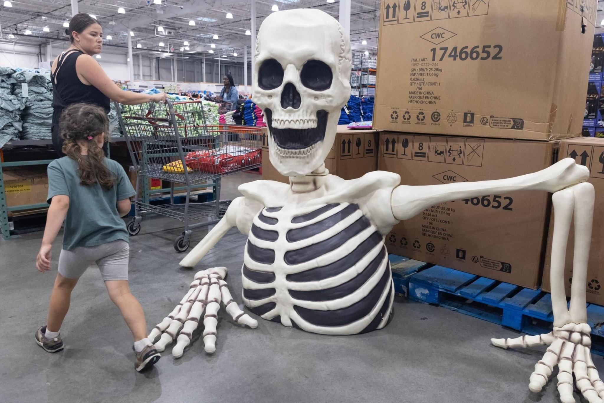 Customers walk past Halloween decorations 