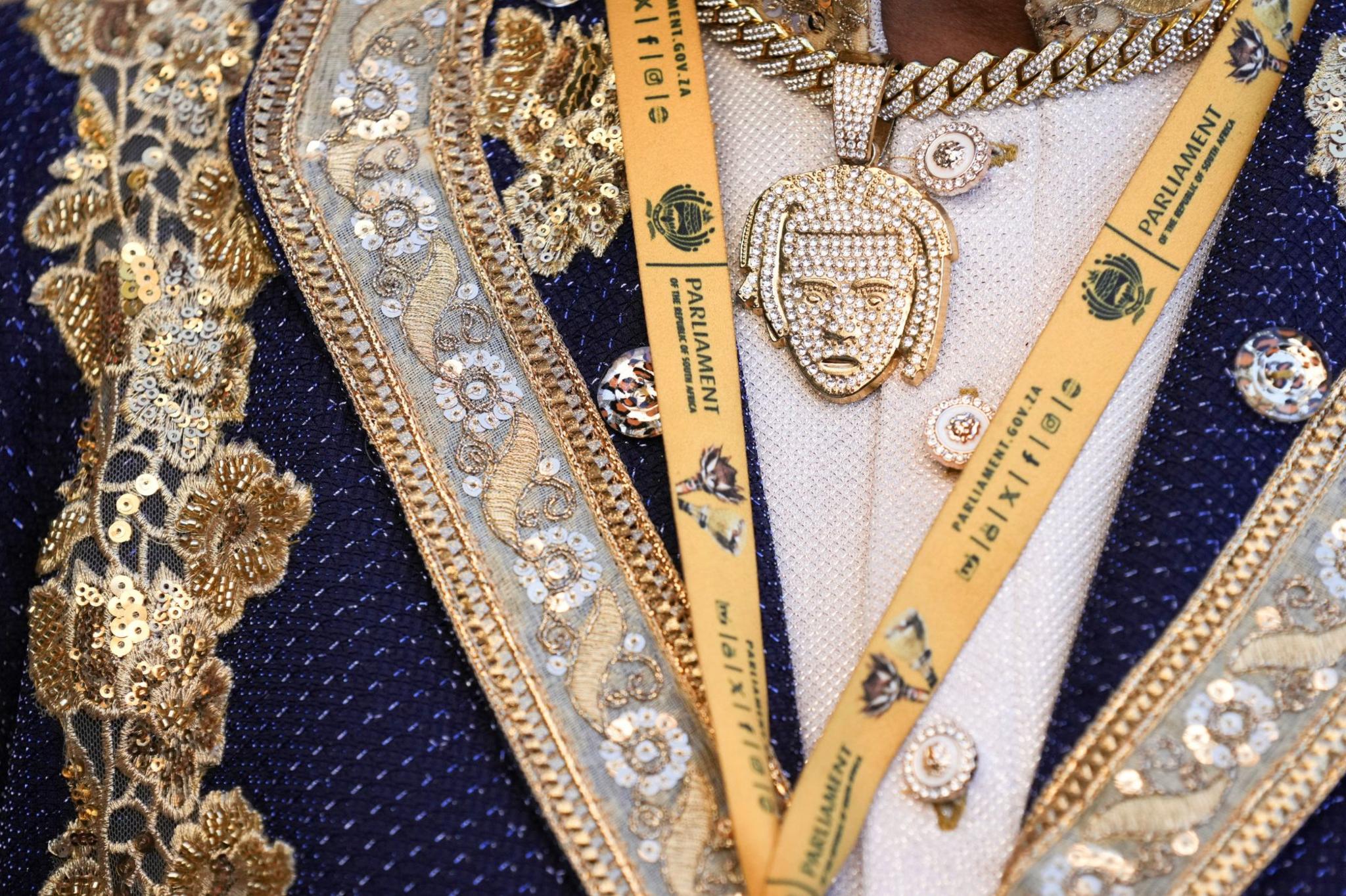 A close-up image of a gold necklace with sparkling diamond inset on the necklace.