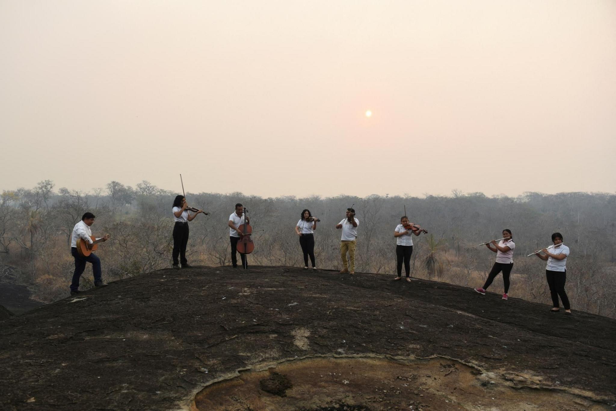 Members of the Misional Padre Martin Schmid Music School play their instruments on a hill destroyed by wildfire