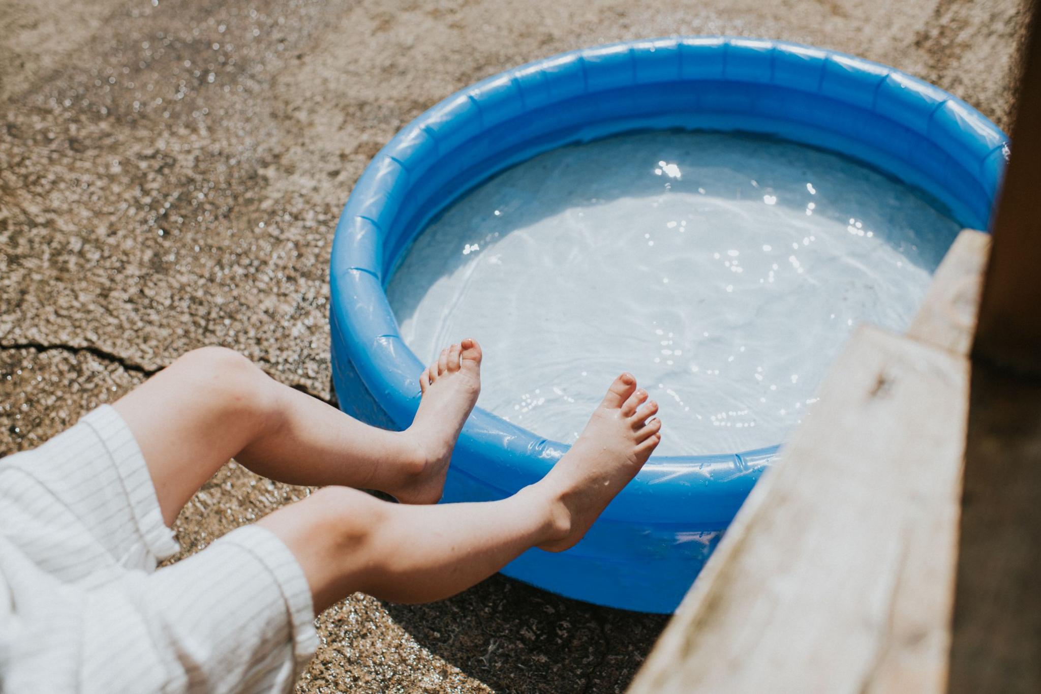Child's feet by a paddling pool