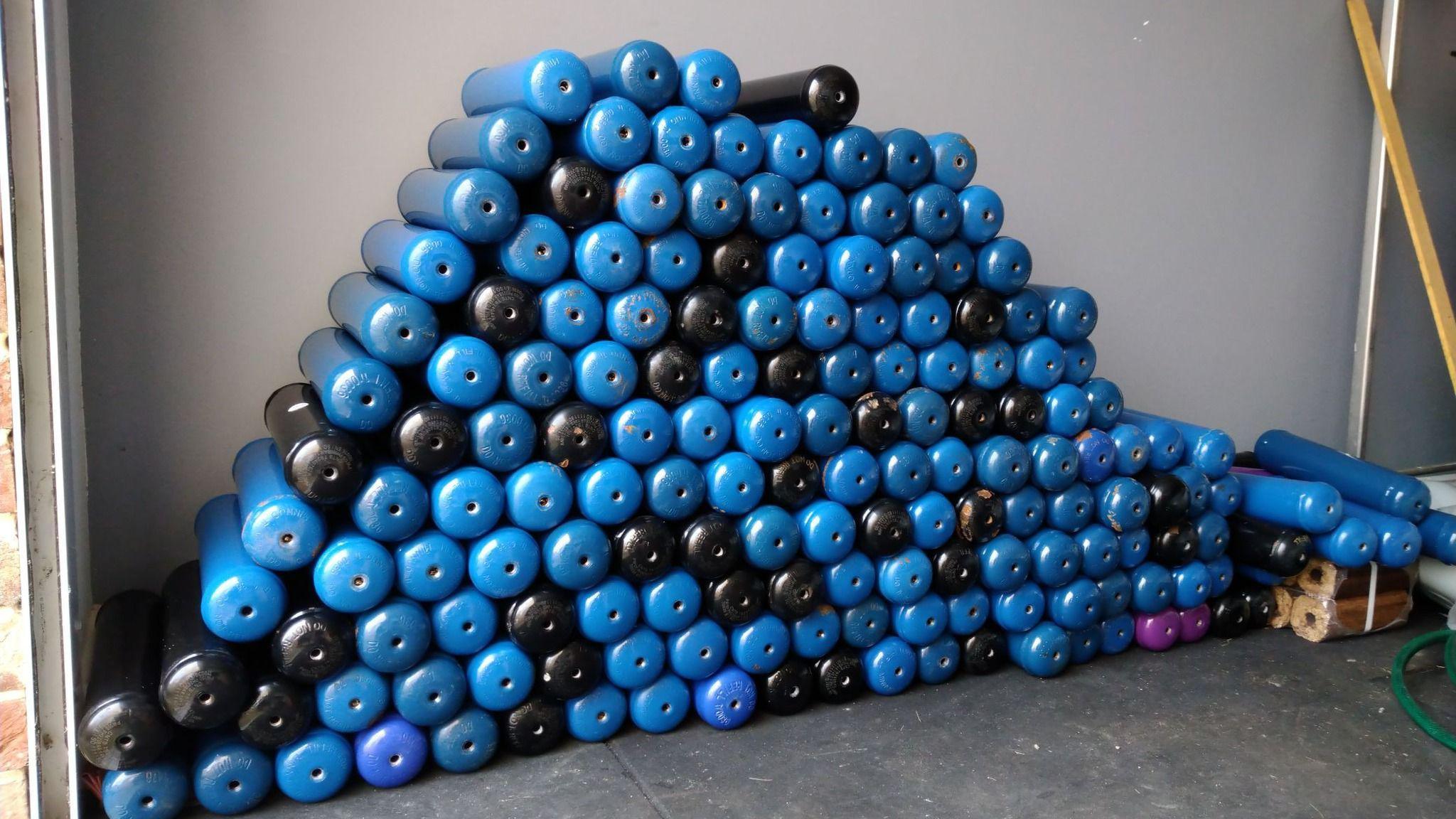 An almost triangular shape of about 150 blue and black nitrous oxide canisters stacked in the garage of Mr Chapman.
