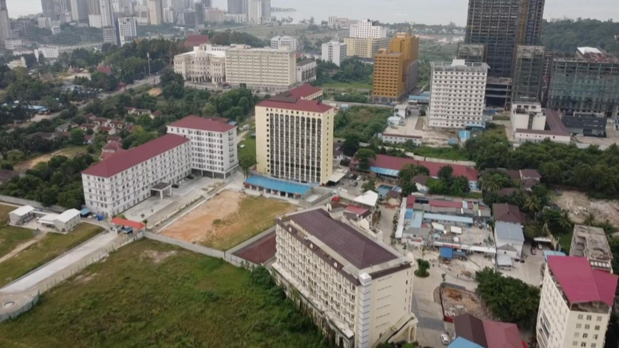 An aerial view of multiple white multi-storey buildings, and park space in between them