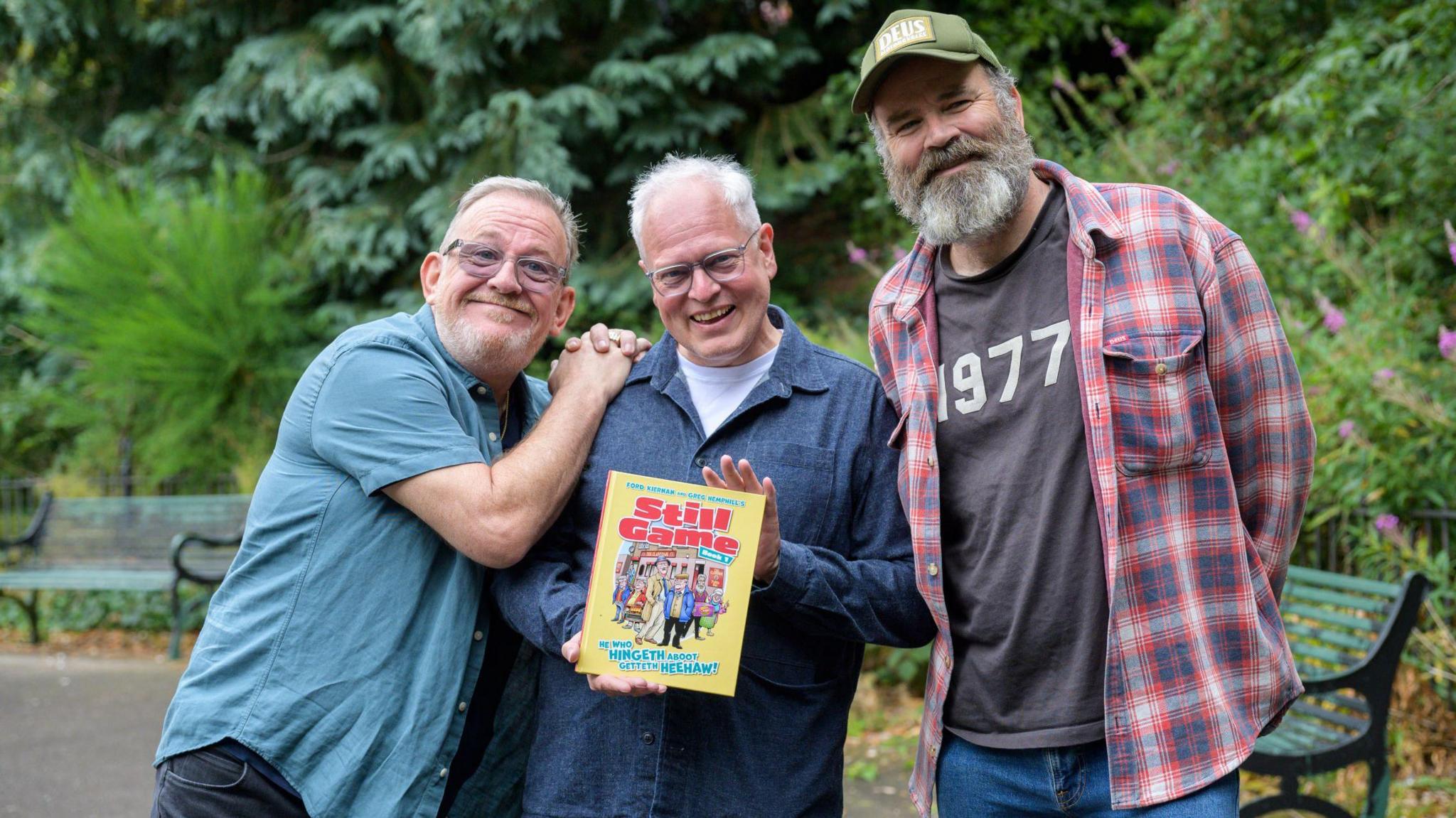 Ford Kiernan, Gordon Tait and Greg Hemphill, with Gordon Tait holding up a copy of the new Still Game comic book 