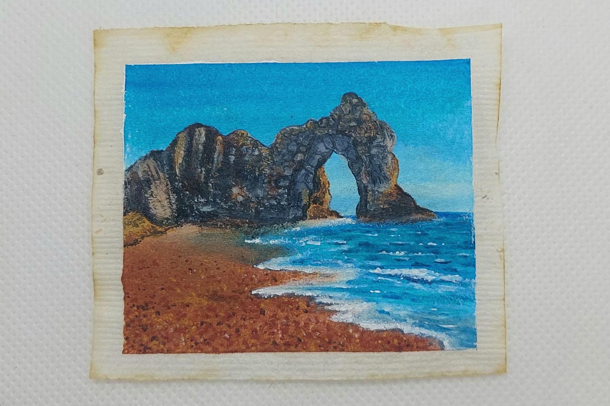 The limestone arch of Durdle Door and beach, painted on a used teabag.