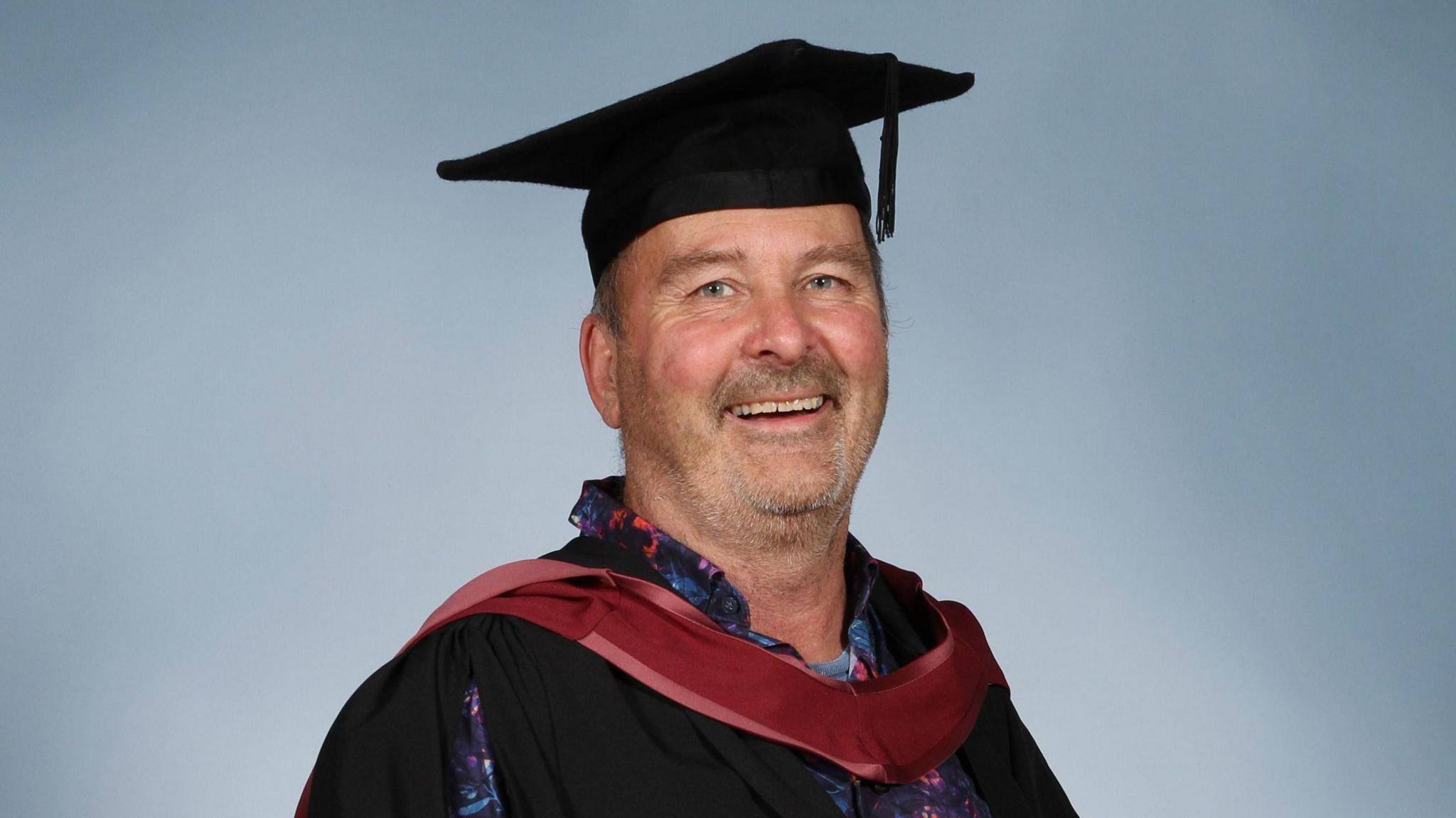 Jonny Clothier, wearing a graduation cap and gown