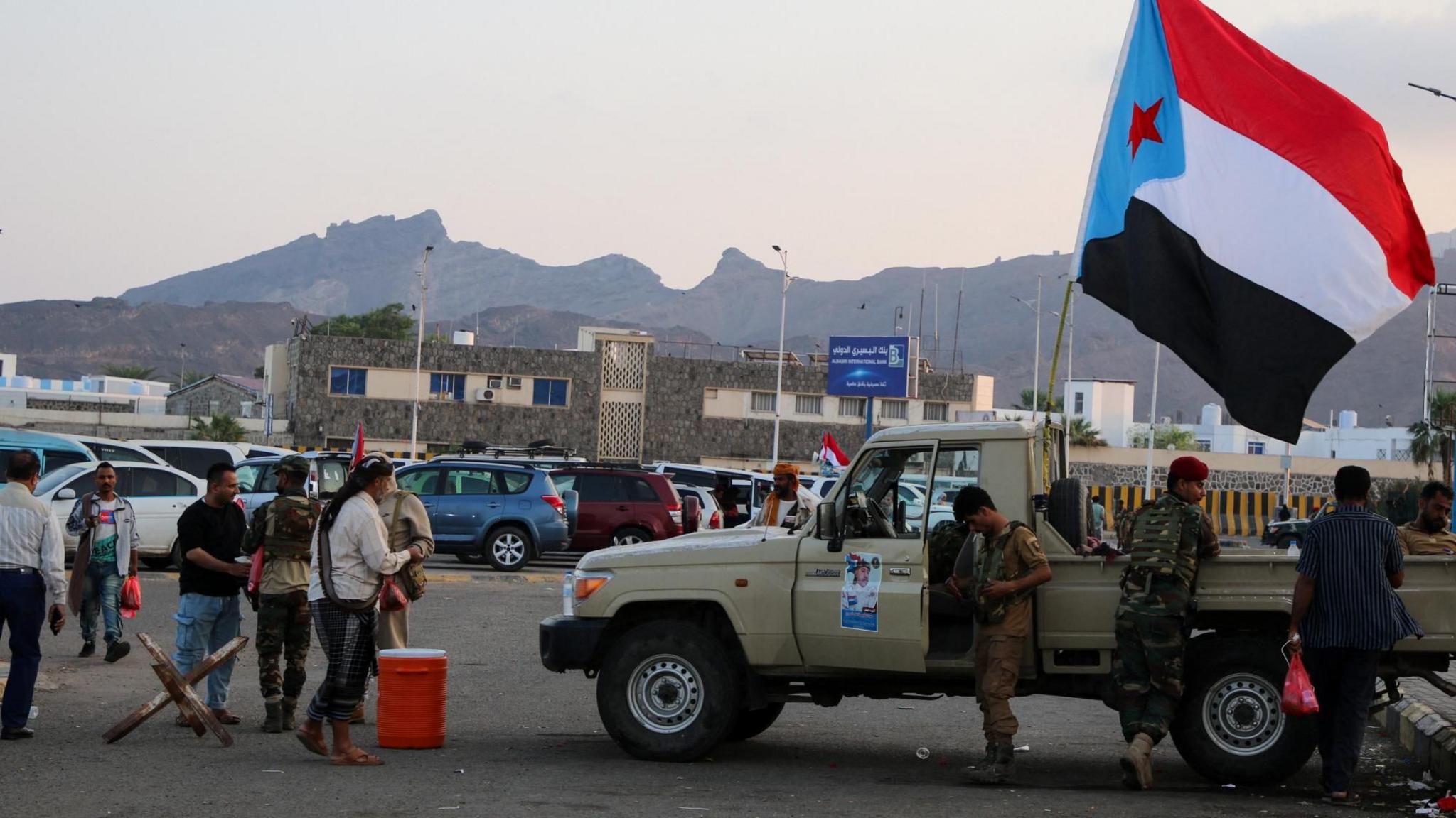 Një flamur i Këshillit Kalimtar Jugor (STC) separatist i mbështetur nga Emiratet e Bashkuara Arabe valëvitet mbi një kamionçinë ushtarake në një tubim nga mbështetësit e STC në Aden, Jemen (1 janar 2026)