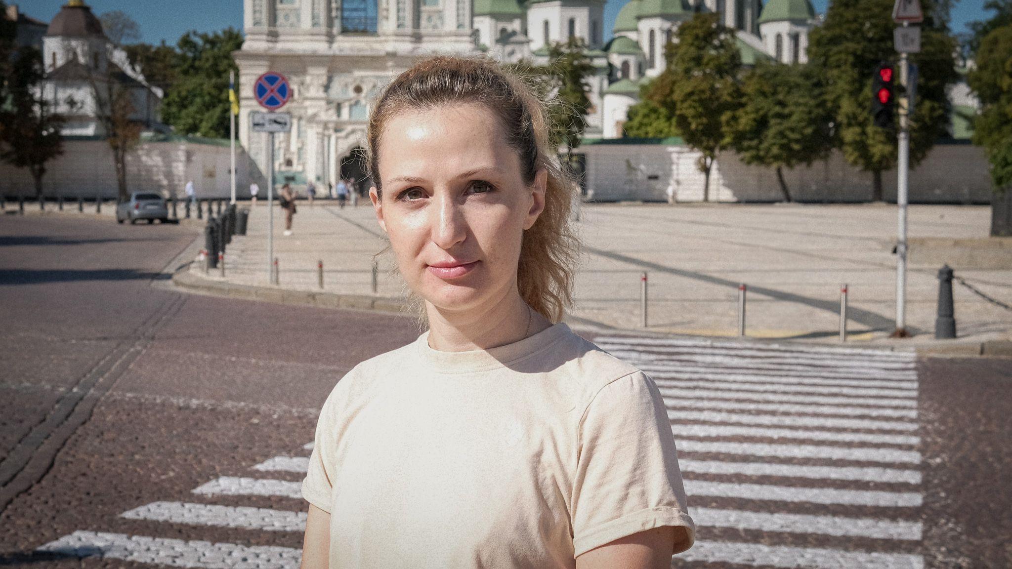 Maria Drachova dressed in a light T-shirt standing in front of a zebra crossing