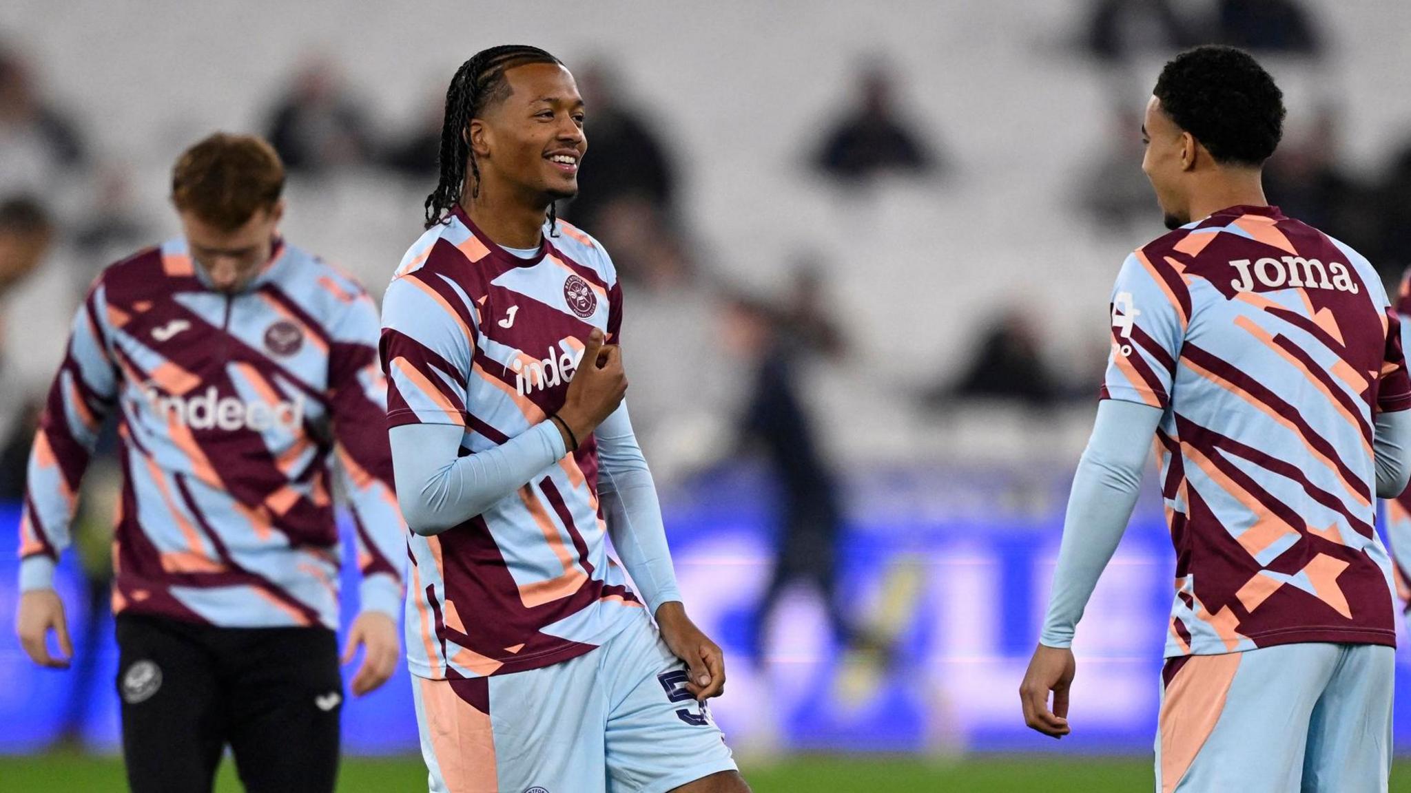 Josh Stephenson warms up with his Brentford team-mates before an FA Cup tie against West Ham. He is wearing a sky blue kit with claret and pink markings.