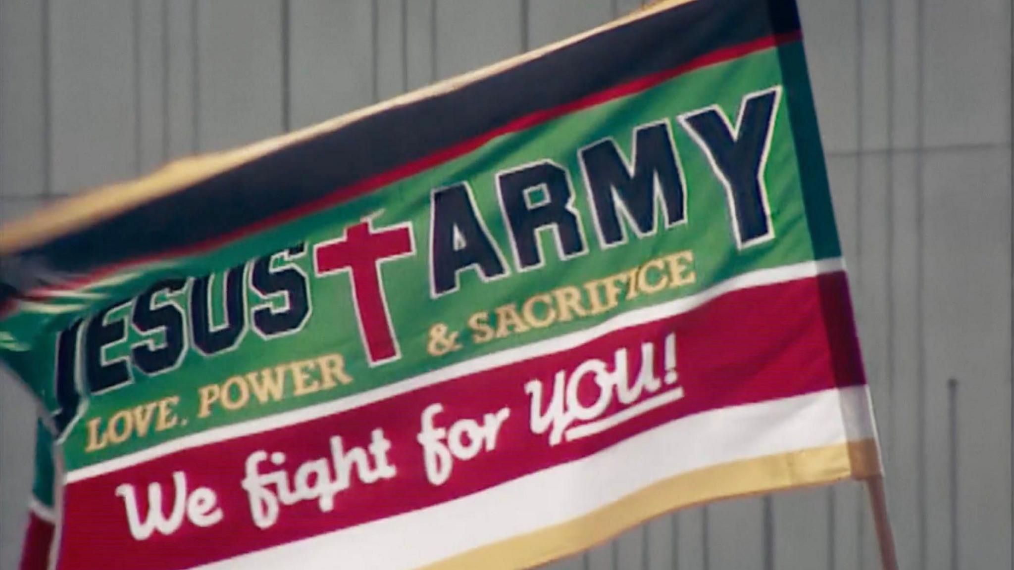 The Jesus Army flag in green and red with a large red cross, reads 'Love, Power & Sacrifice; We right for YOU!'