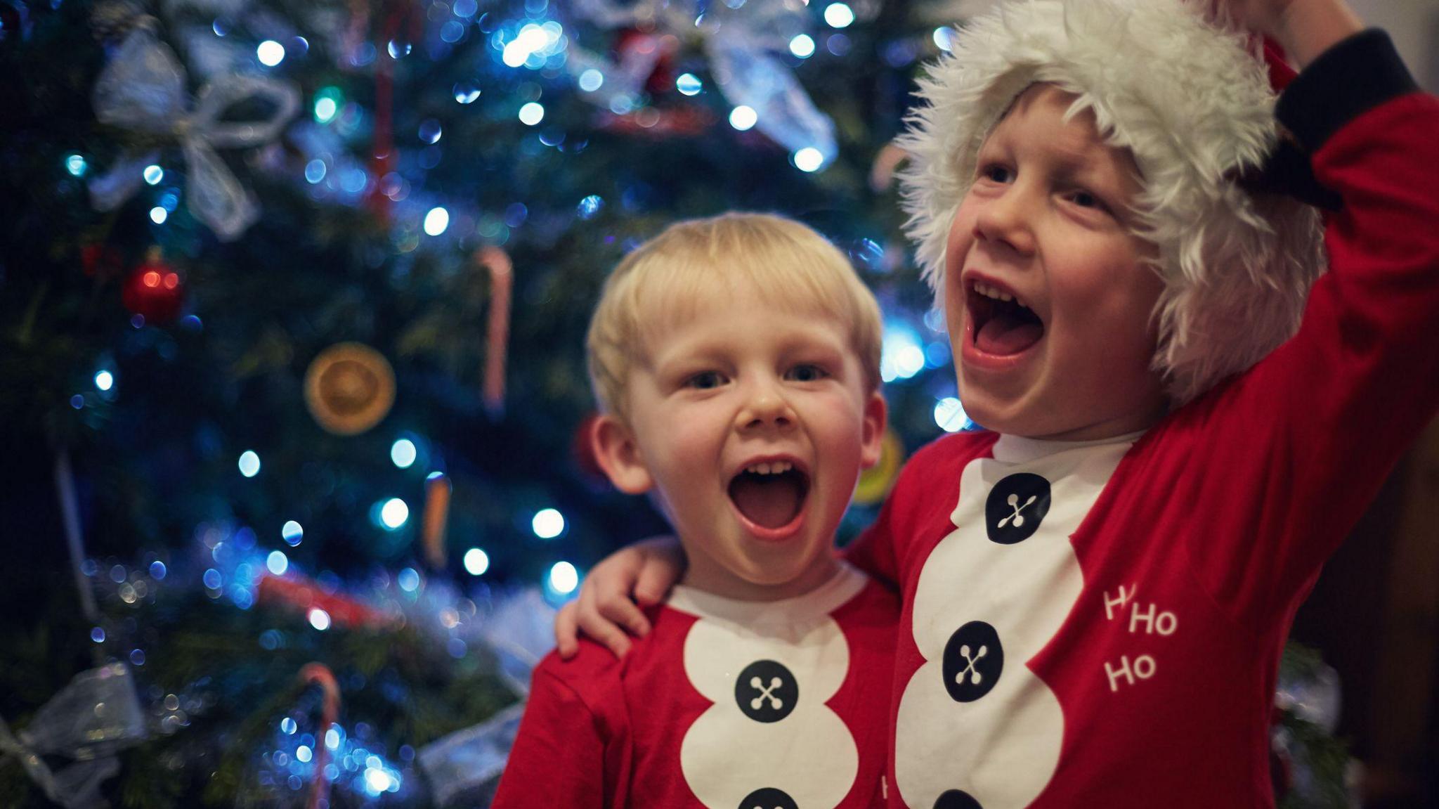 Children singing by the Christmas tree