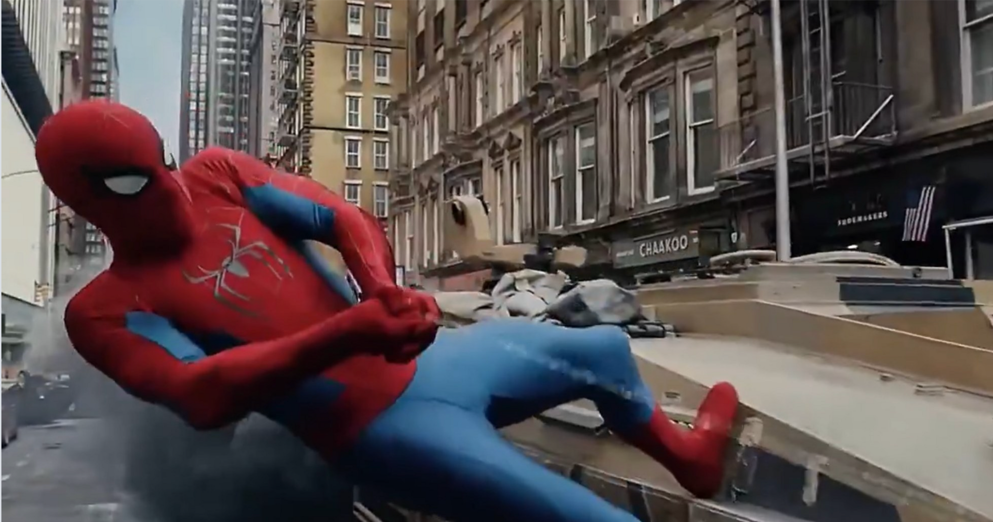 A shot from the new Spider-Man film as the masked hero holds on to a speeding tank using his web.