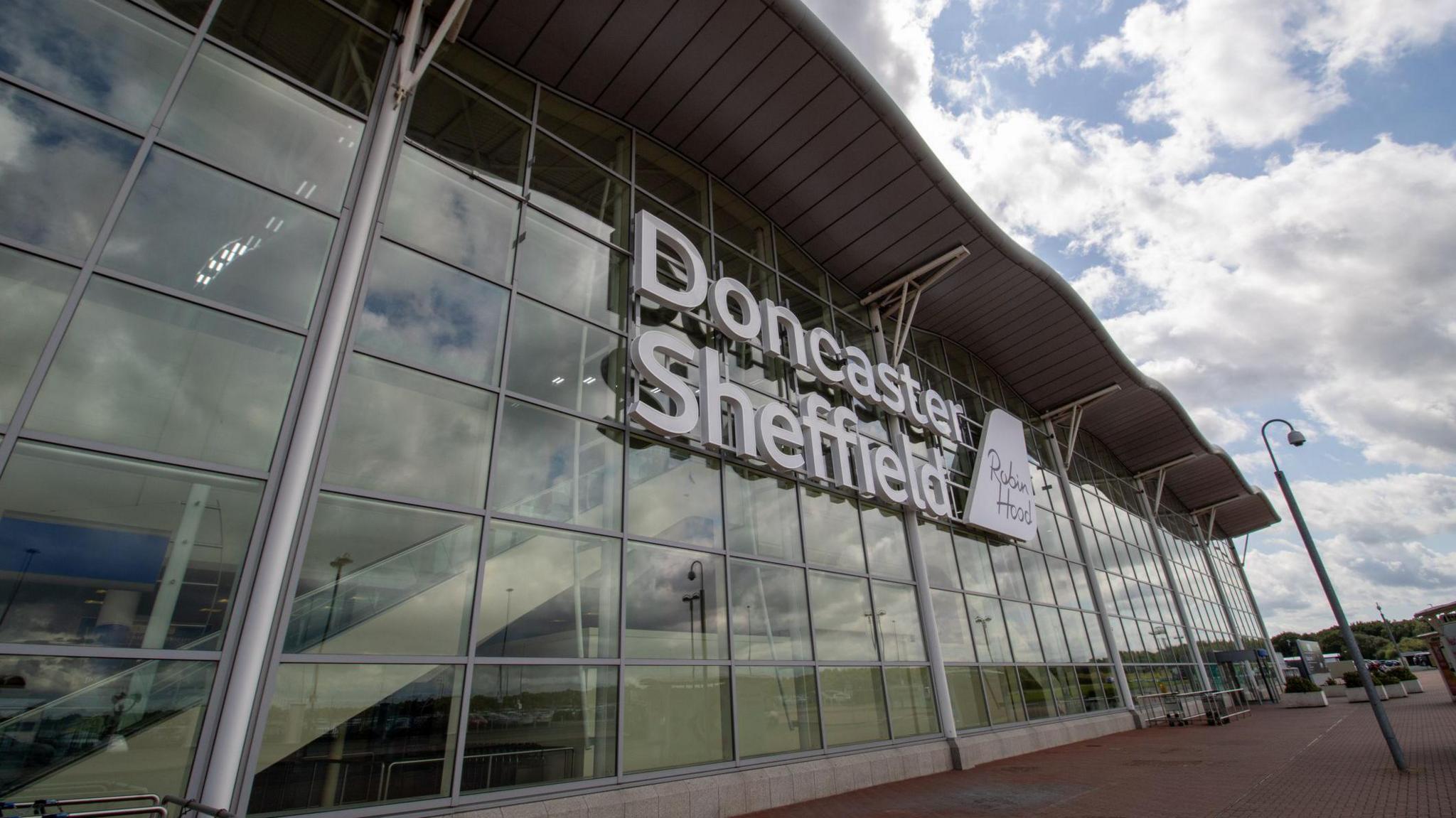 A photo of the glass-fronted entrance to Doncaster Airport. No people can be seen in the photo.