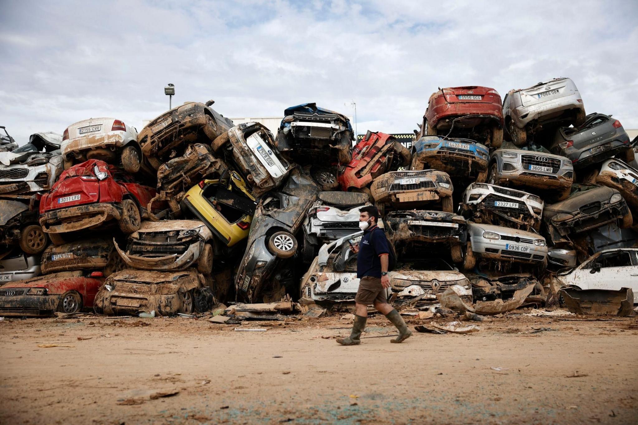 A man tries to find his vehicle in an improvised junkyard in the flood-hit municipality of Massanassa, province of Valencia, Spain