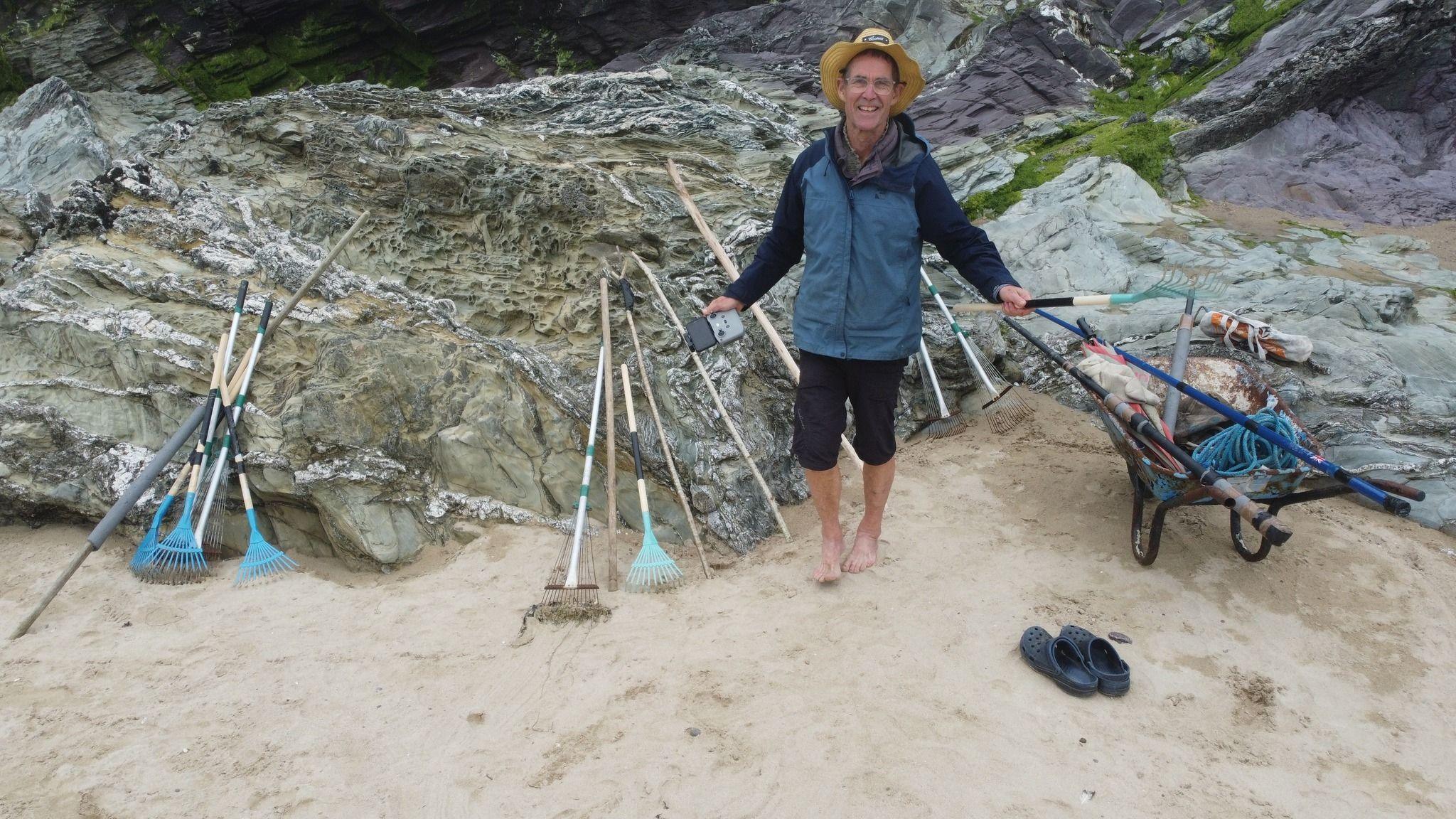 Bill Bartlett on the beach with the tools he uses