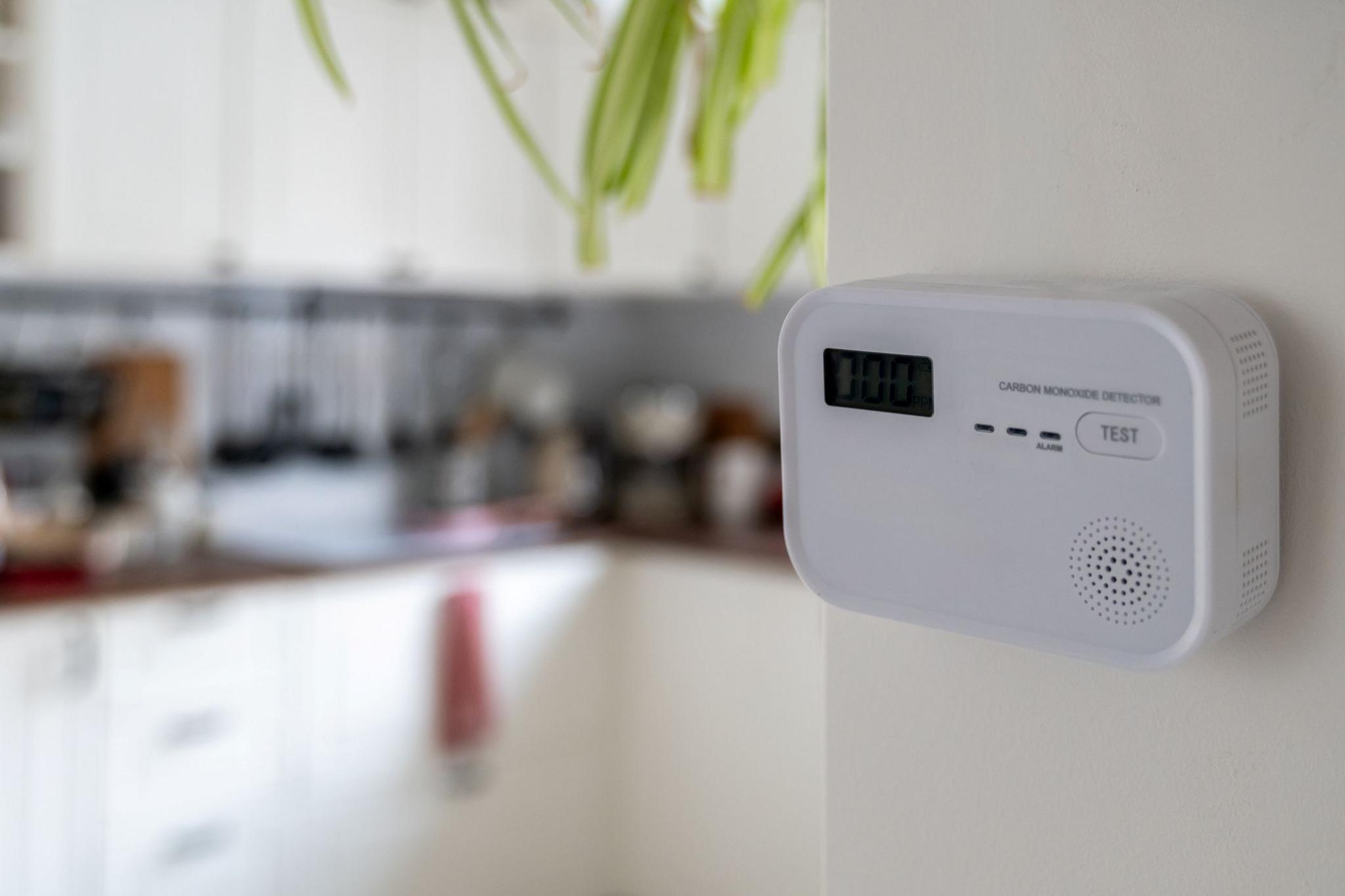 White carbon monoxide detector positioned on kitchen wall, ready to monitor air quality and ensure safety