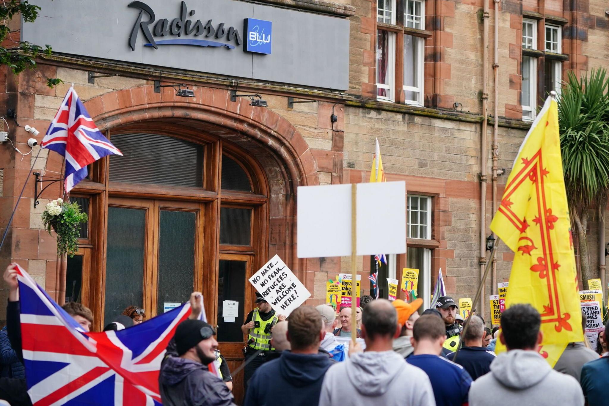 The entrance the the Radisson Blu hotel with one group of protestors looking on at another group
