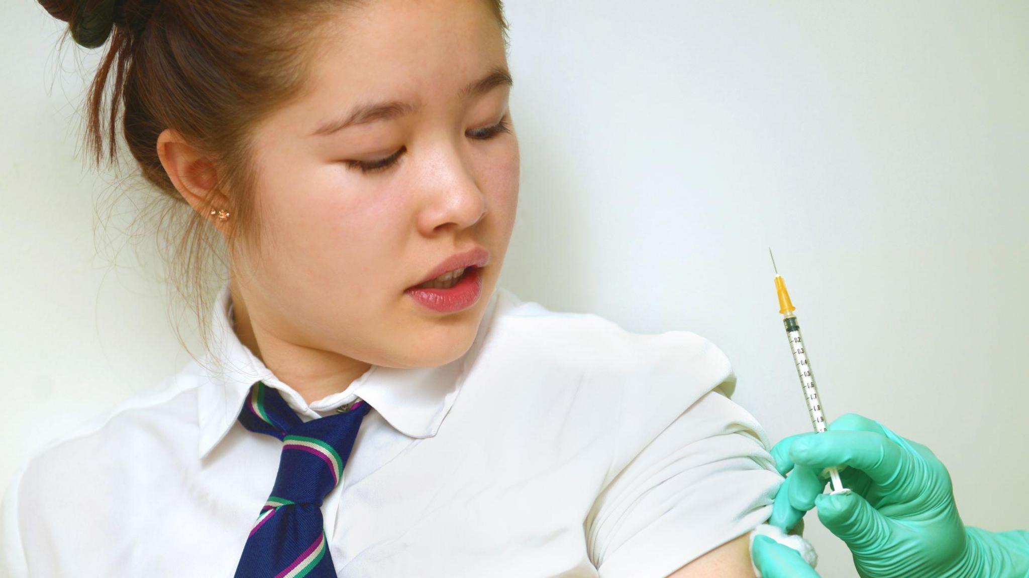 School girl having vaccination