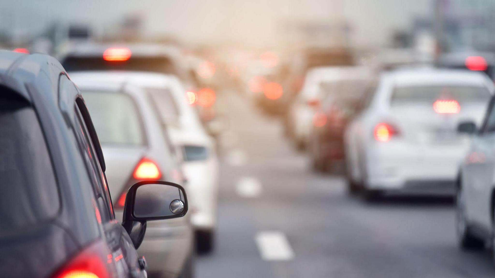 Two long lines of cars sitting on a congested road. 