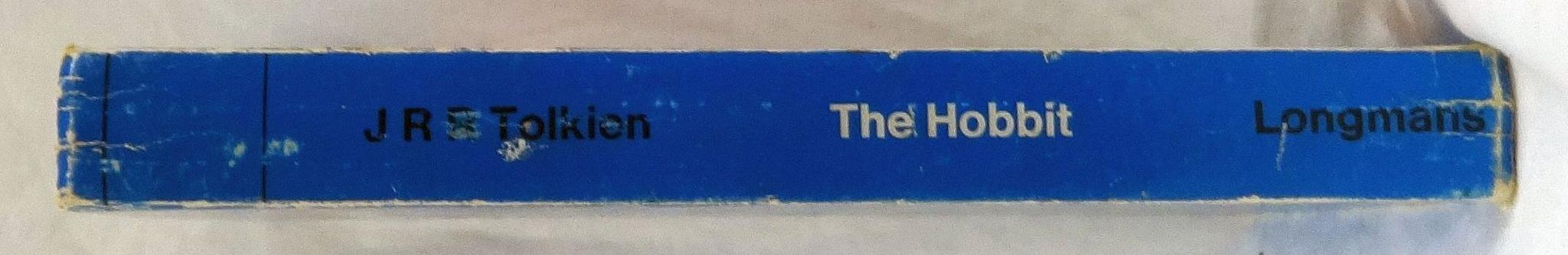 A battered blue book spine of The Hobbit by JRR Tolkien, published by Longmans.