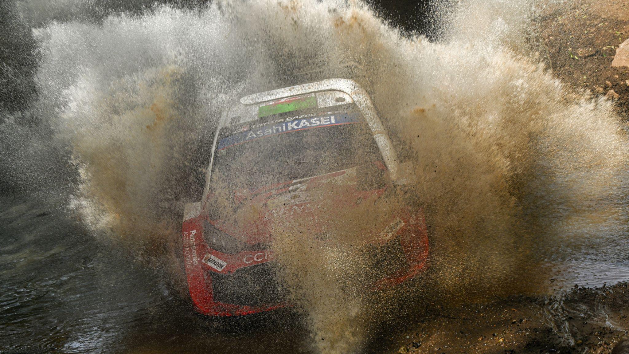 Elfyn Evans' Toyota splashes through muddy water at Safari Rally Kenya