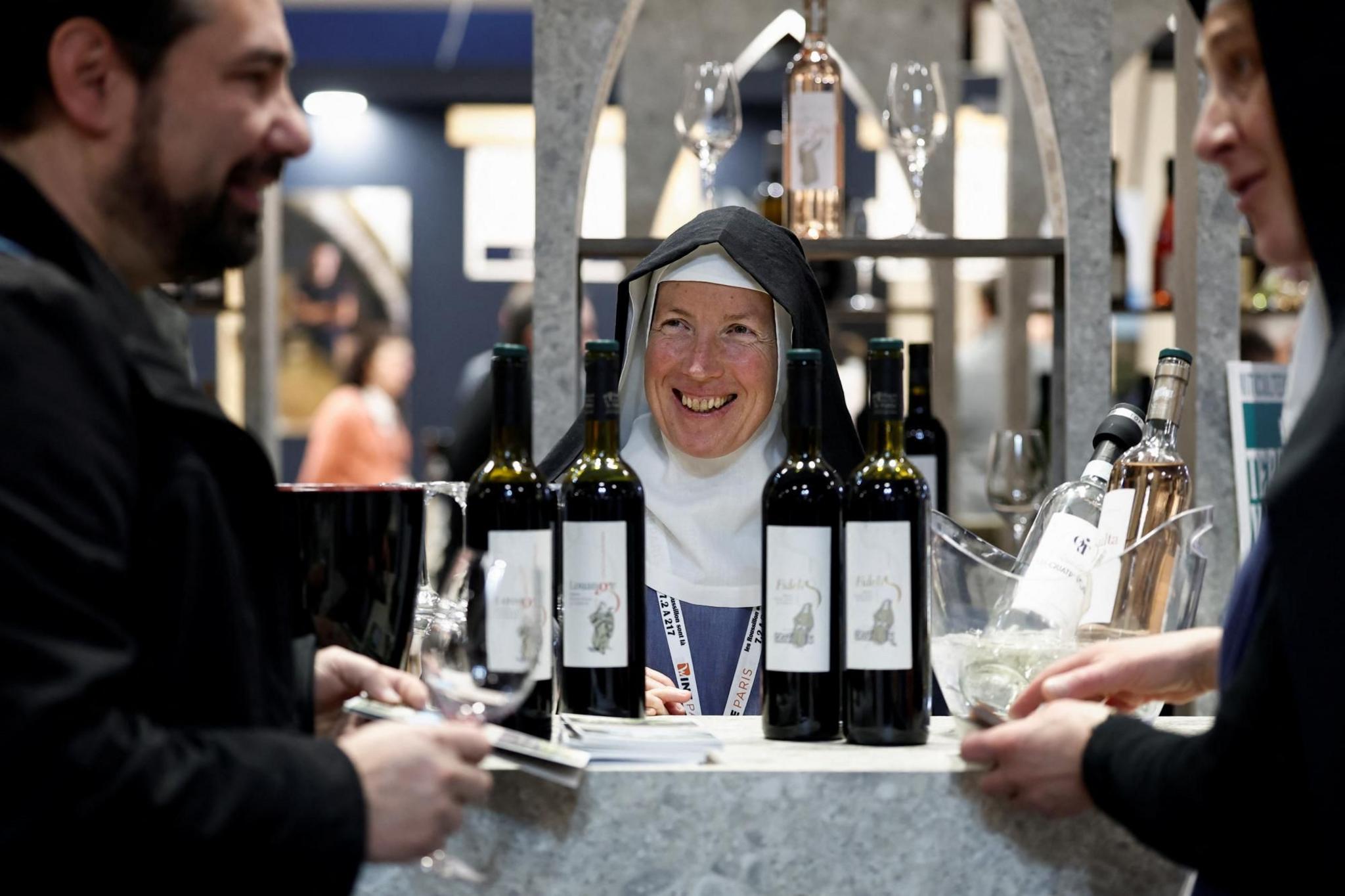 A nun is pictured near bottles of wine at the Wine Paris trade fair in France 
