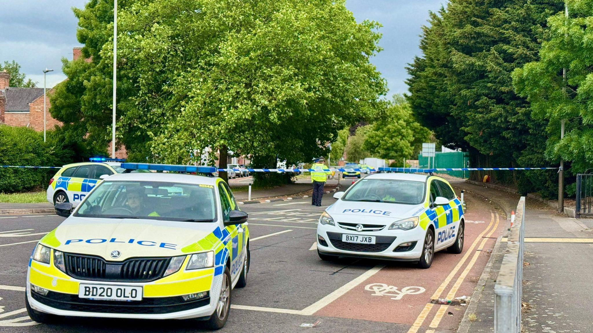Police cars en masse at a cordon across a road
