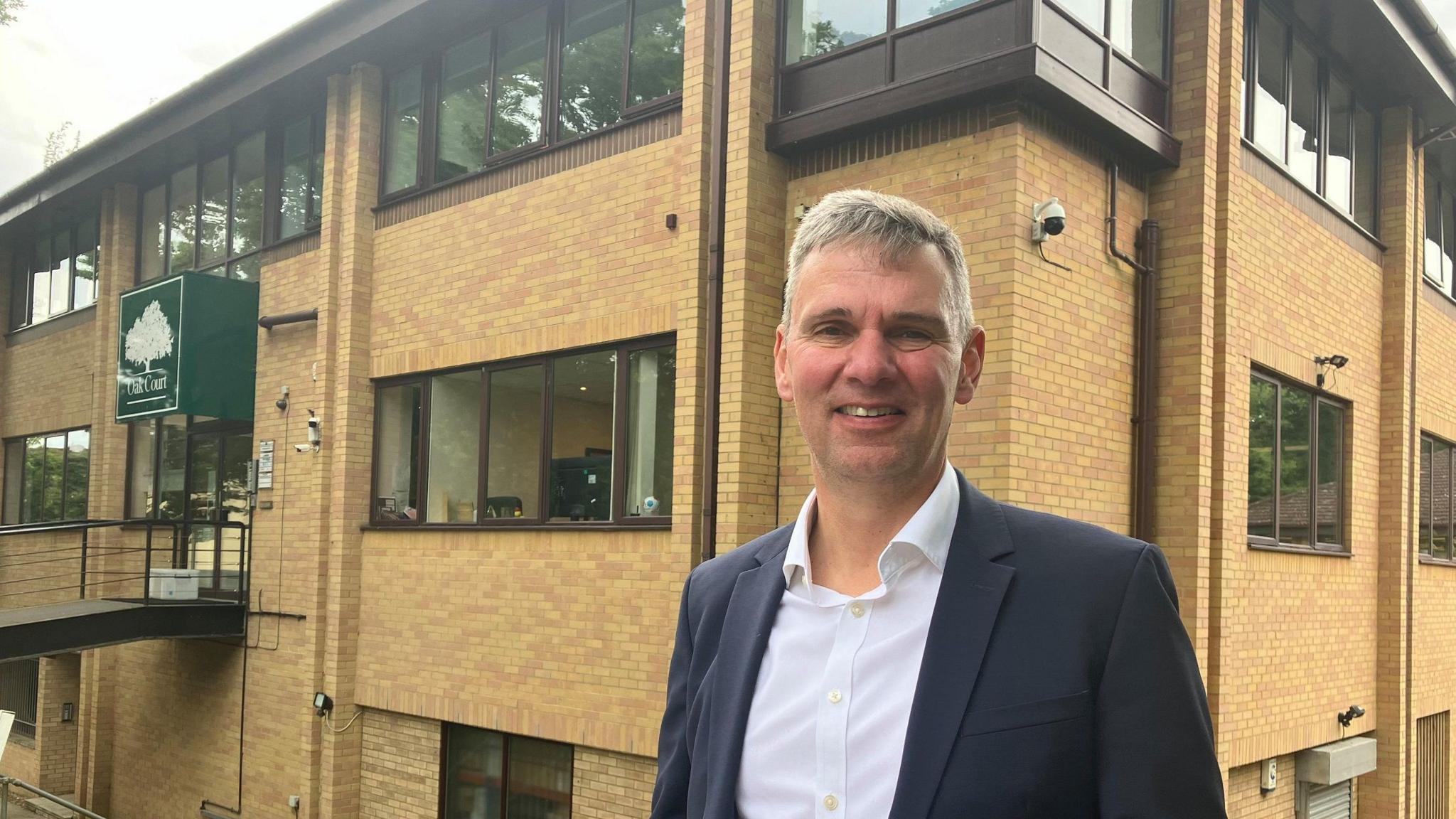 Chris Cooke standing in front of an office block