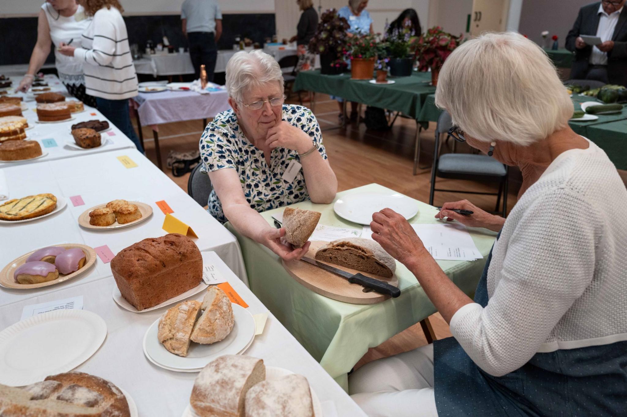 Two women taste one of the loaves on display