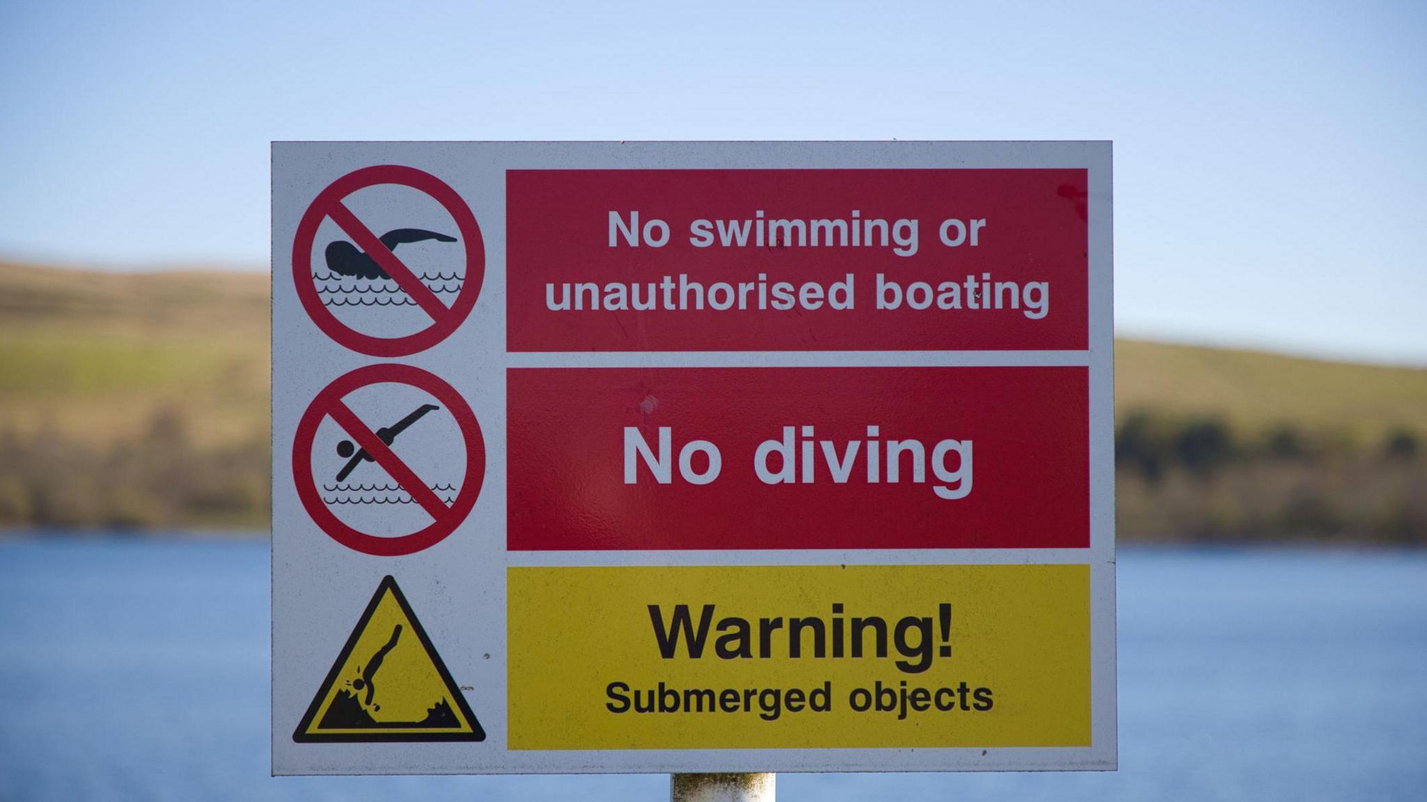 A sign banning swimming at a reservoir