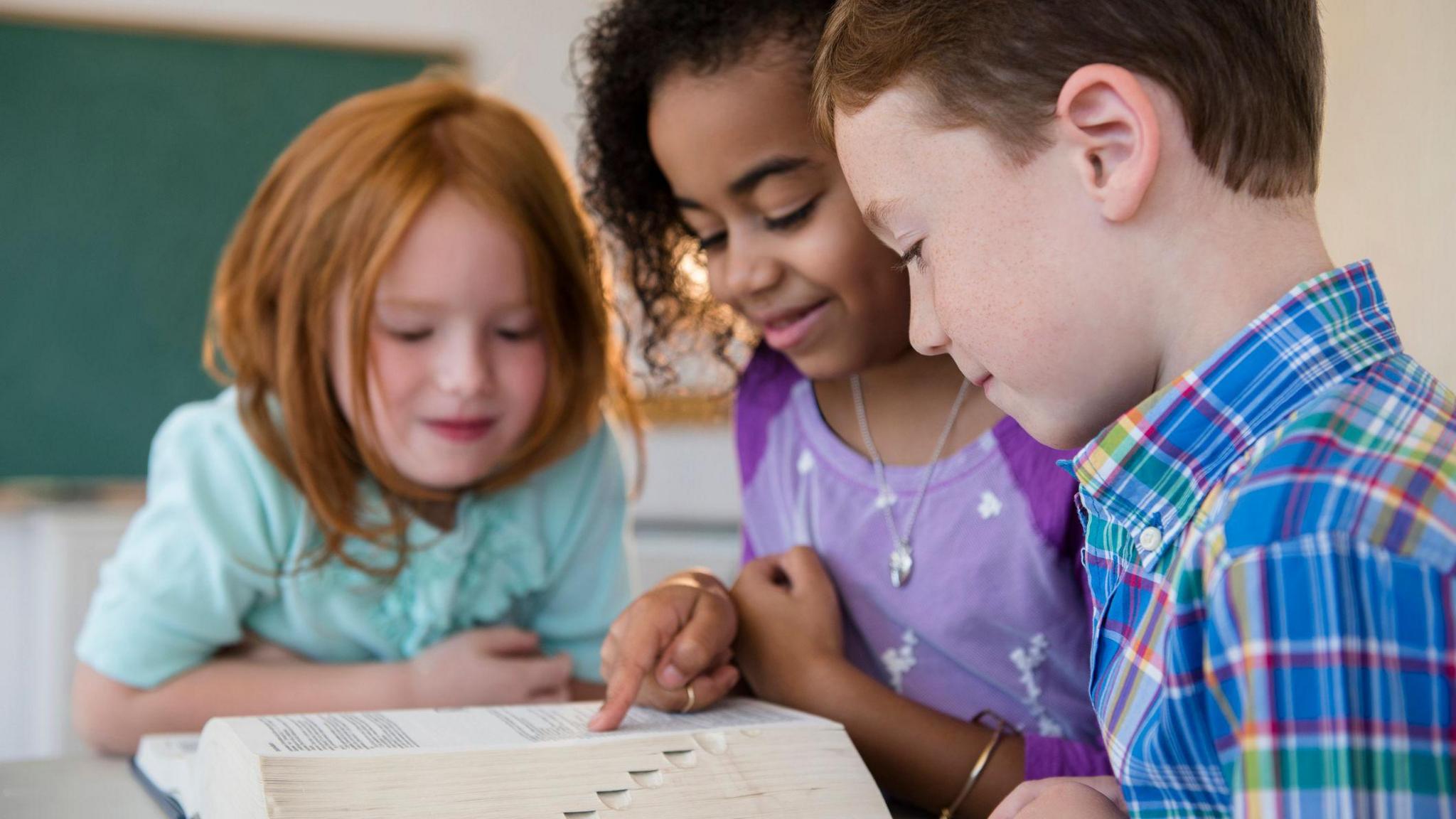 children studying a dictionary